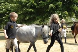 Zwei Kinder führen ein Pony an der Leine auf dem Bernsteinreiter-Hof