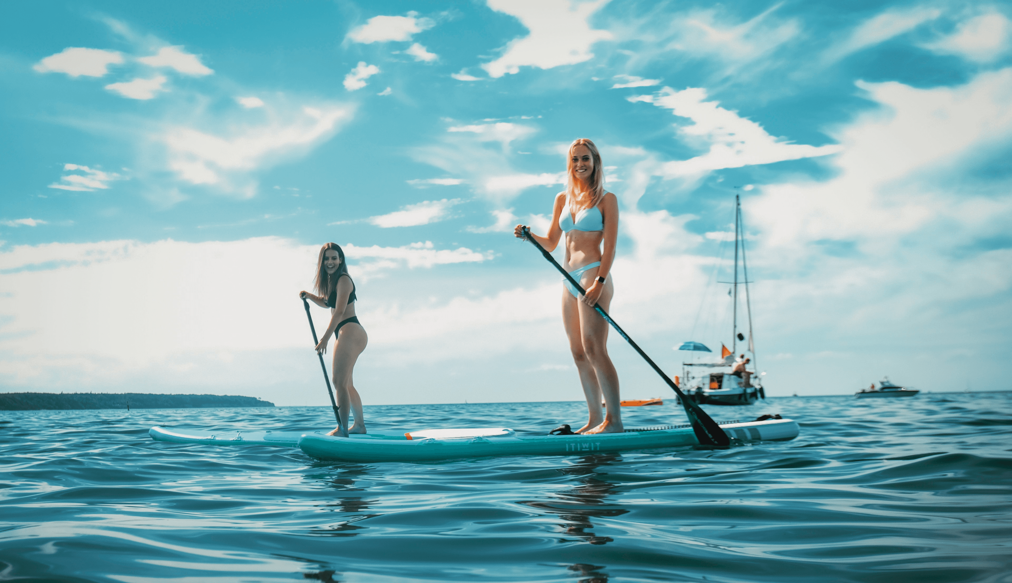Zwei Frauen paddeln auf Stand-Up-Paddling-Boards auf der Ostsee