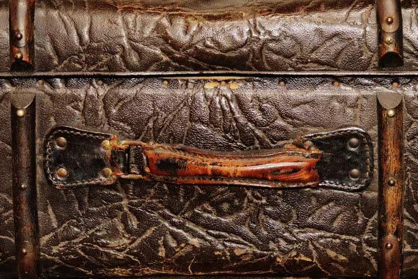 Detailansicht eines alten Lederkoffers mit abgenutztem Griff.