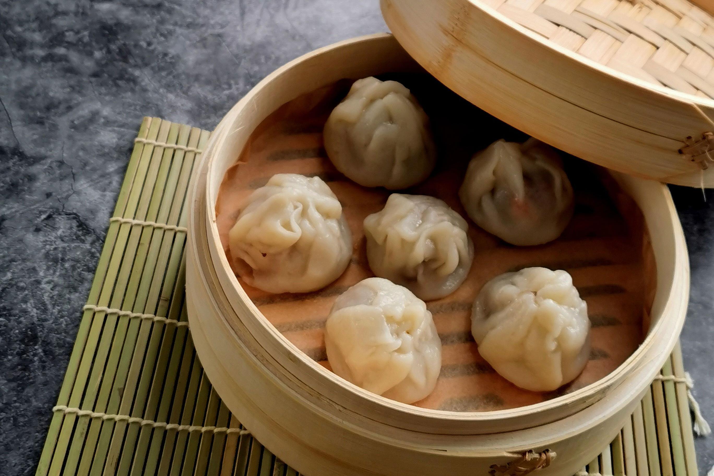 Kern des Kochkurs Vietnamesische Küche: Authentische Teigtaschen (Há Cào) in eiem Bambus-Behälter auf einer Bambusmatte.