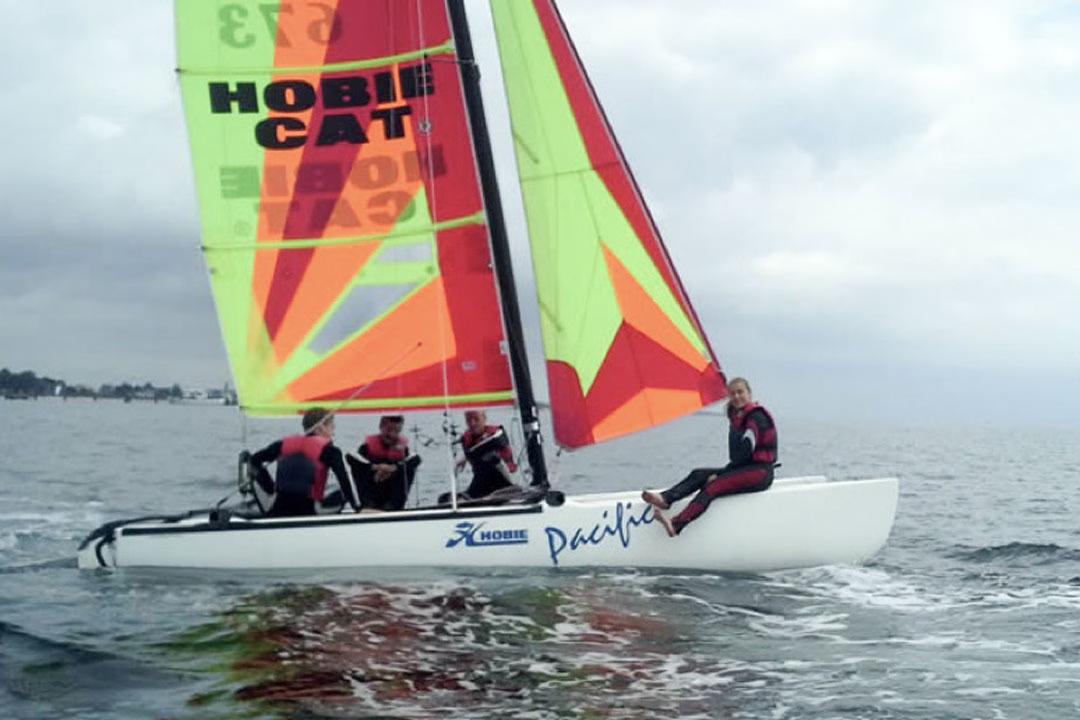Menschen segeln auf einem Katamaran in der Ostsee.