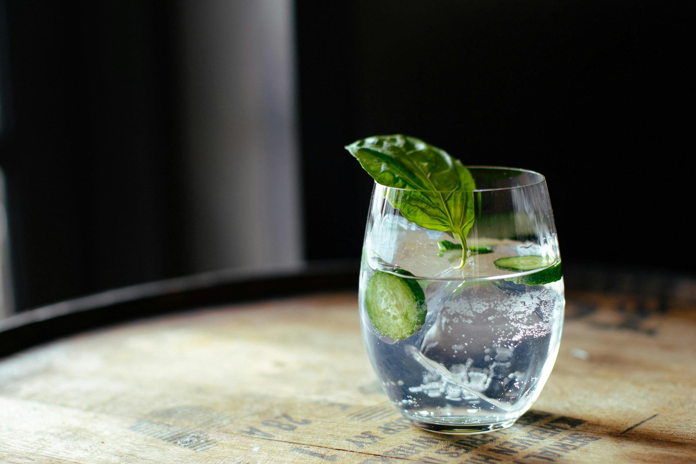 Ein Glas mit Gin auf einem Holzfass