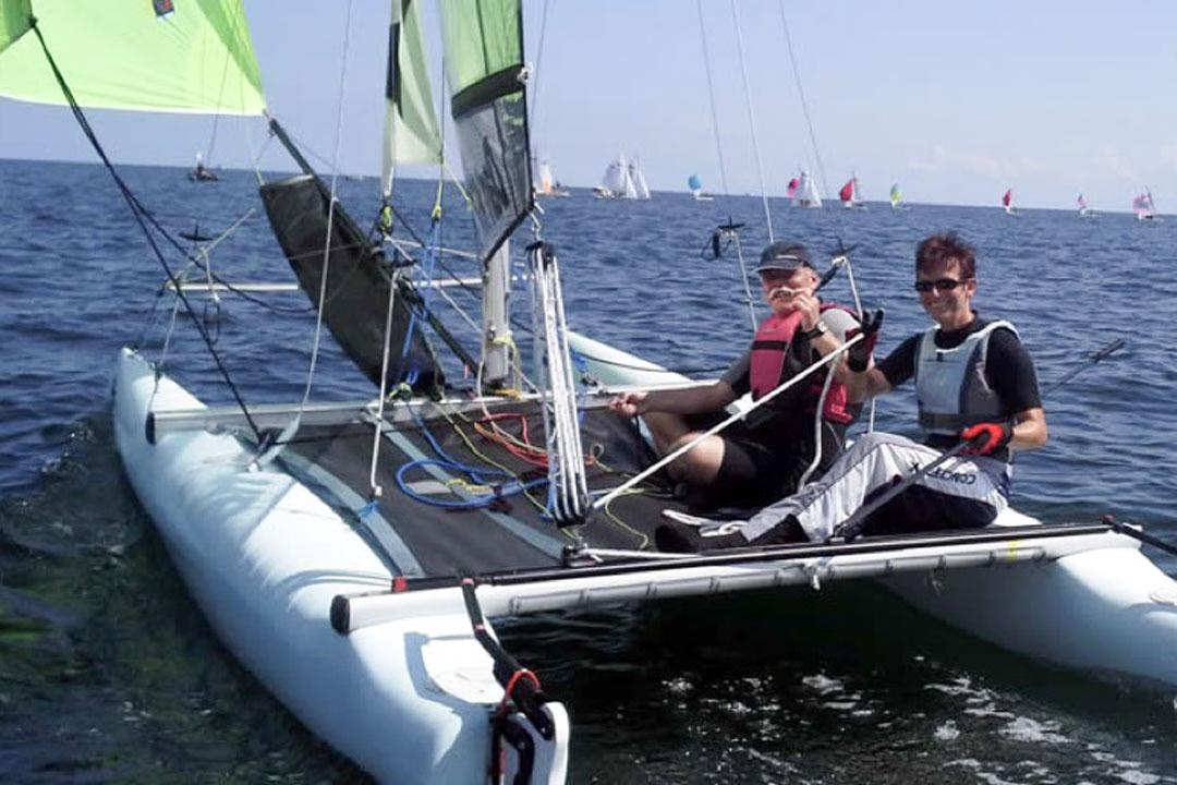 Zwei Personen segeln auf einem Katamaran in der Ostsee.