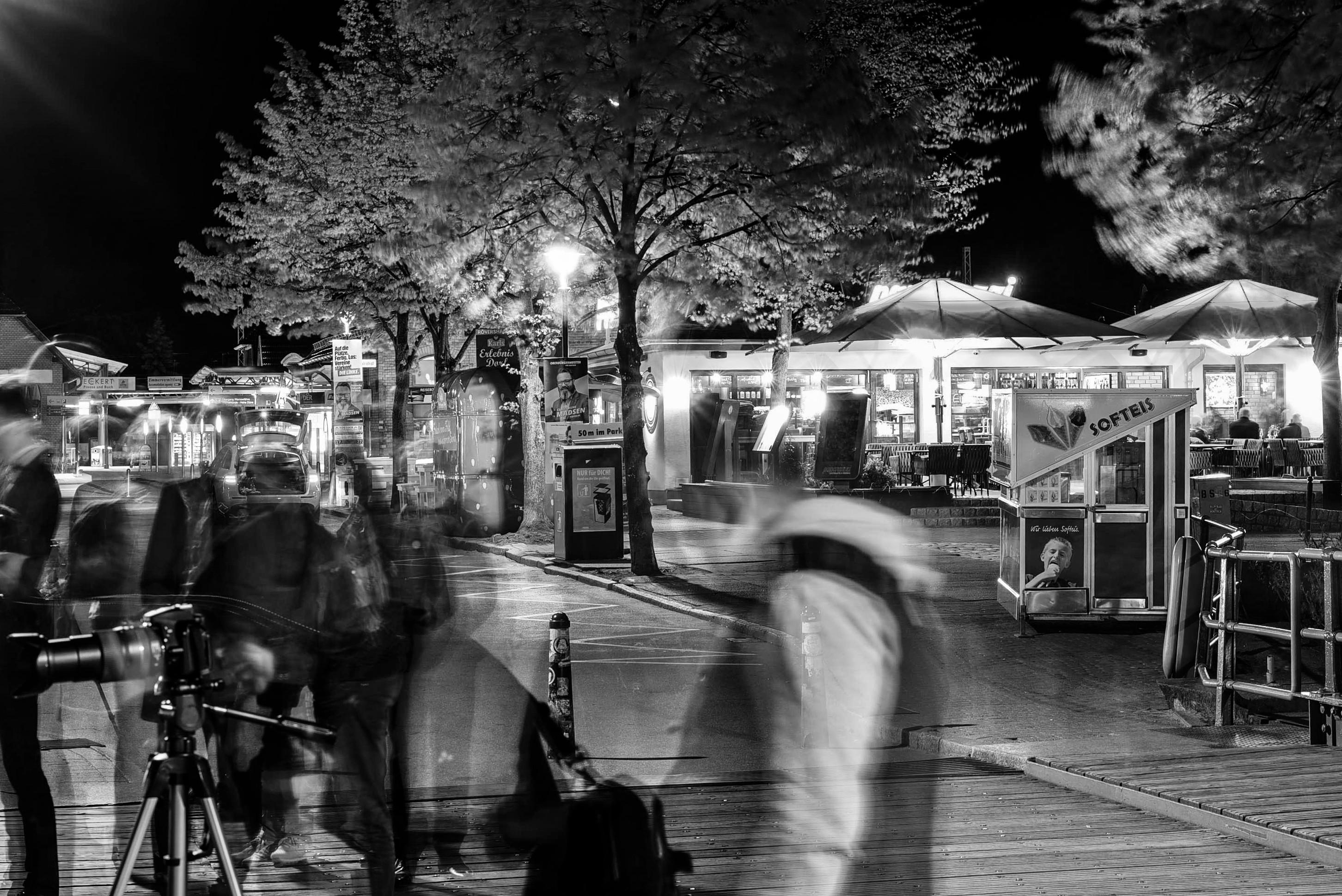 Seepromenade mit beleuchteten Bars bei Dunkelheit