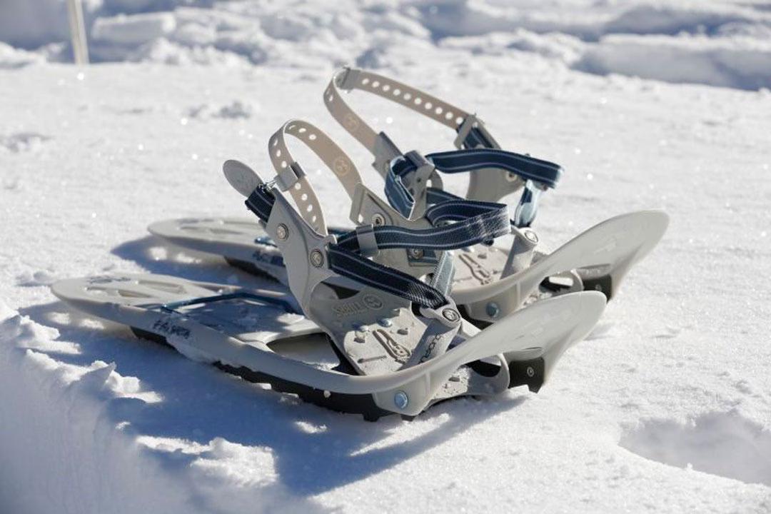 Ausrüstung fürs Schneeschuhwandern: Schneeschuhe liegen bereit im glitzernden Schnee.