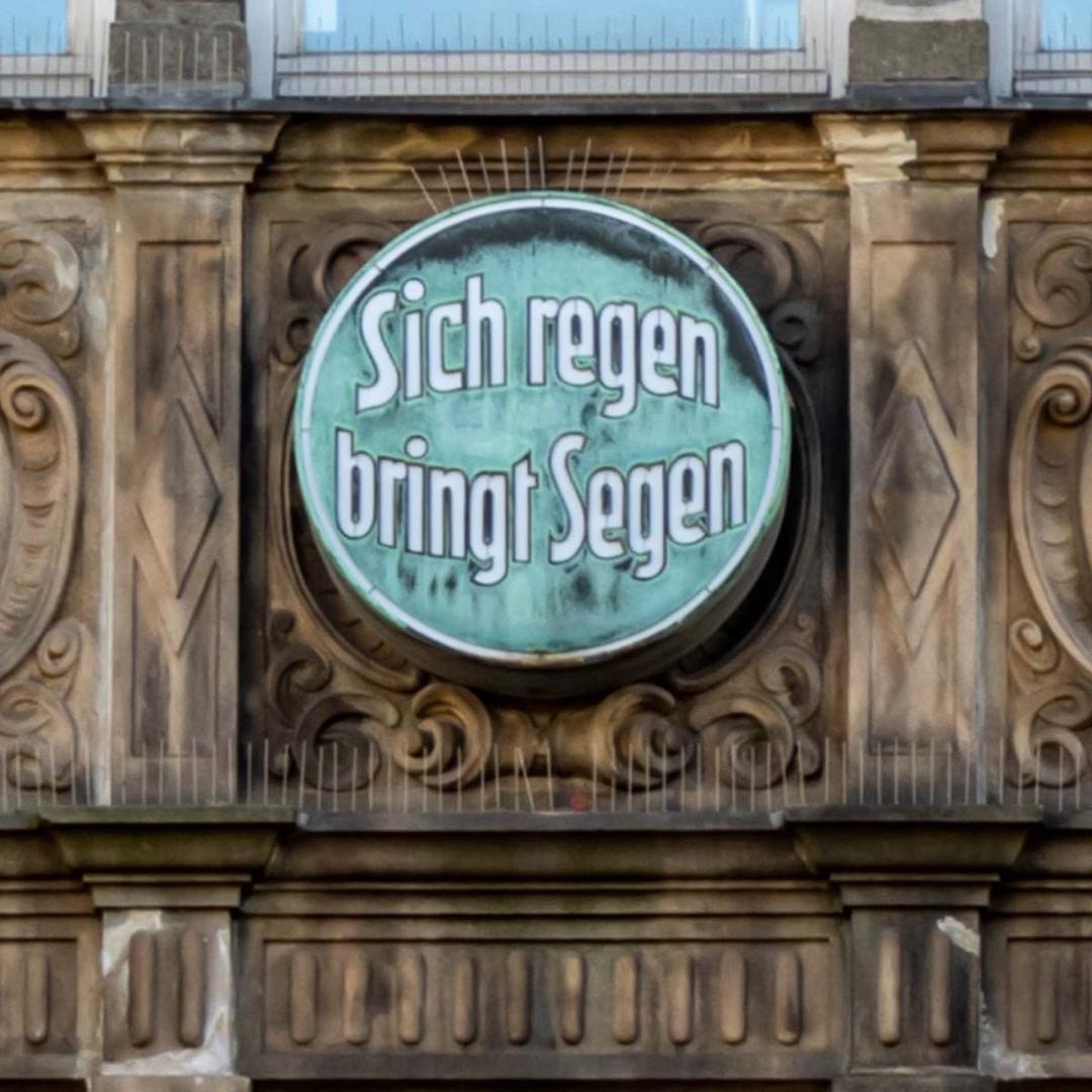 Alte Fassade mit rundem Schriftzug „Sich regen bringt Segen“ – entdeckt auf der St.-Marien-Schnitzeljagd.