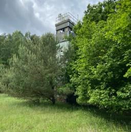 Ein ehemaliger DDR-Grenzturm hinter Bäumen bei Travemünde
