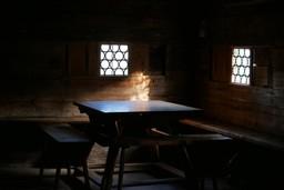Licht fällt auf einen Tisch in einer dunklen Bauernstube