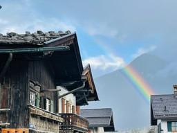 Bauernhäuser mit Holzbalkonen und einem Regenbogen in Garmisch-Partenkirchen