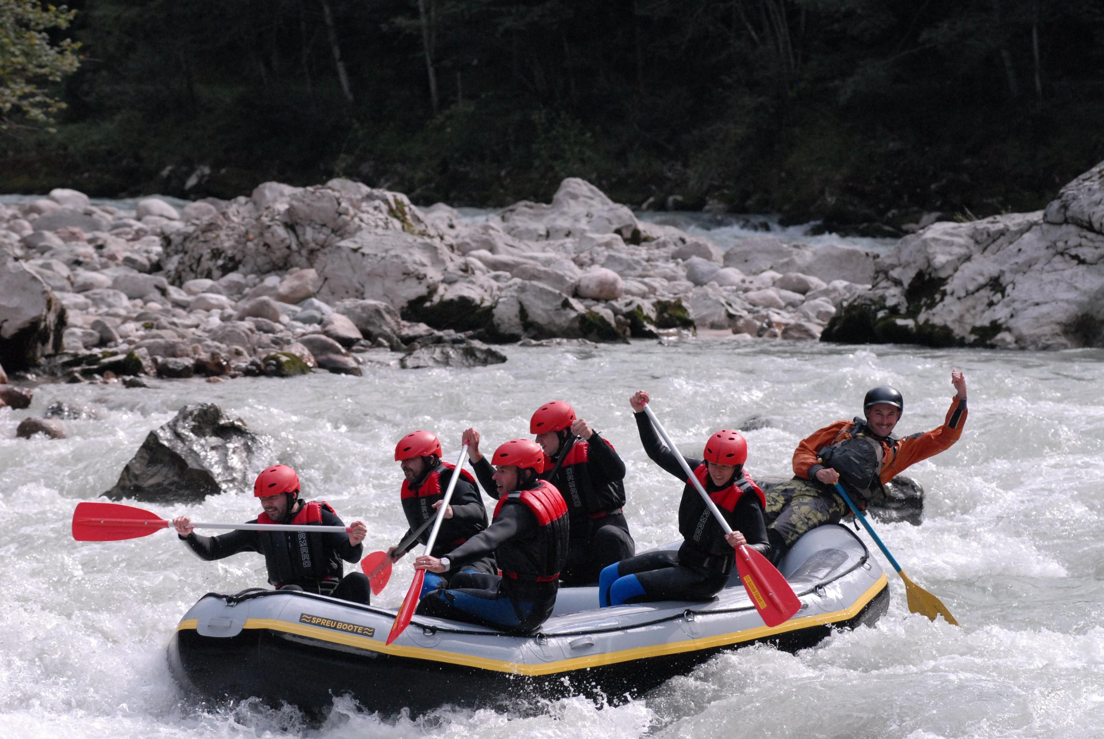 Eine Gruppe von Menschen befährt mit einem Rafting-Boot einen Fluss