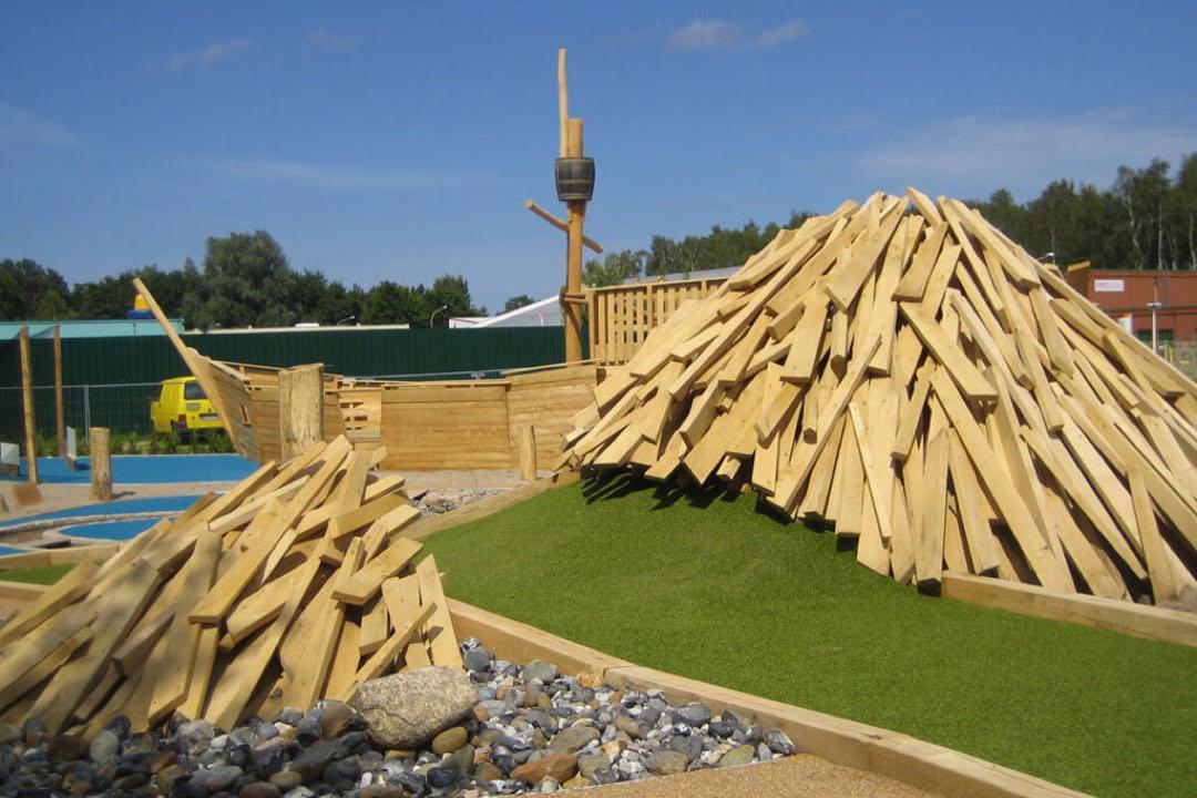 Ein Vulkan aus Holzscheiten auf der
Minigolf-Anlage Piraten der Ostsee, durch den Minigolf-Spieler hindurch spielen müssen.