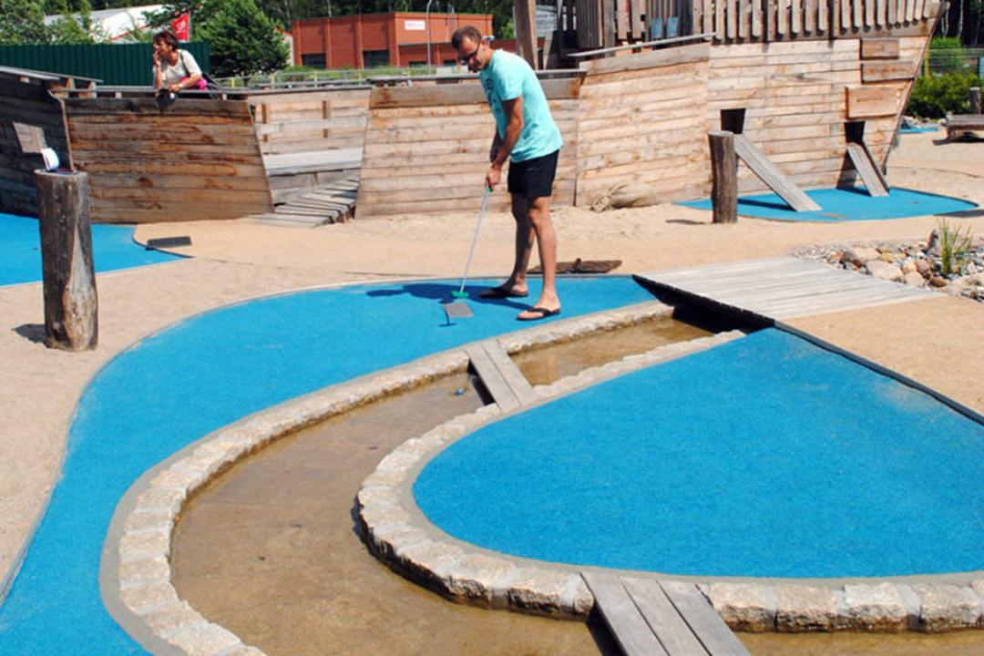 Mann spielt Minigolf auf der Minigolf-Anlage Piraten der Ostsee.