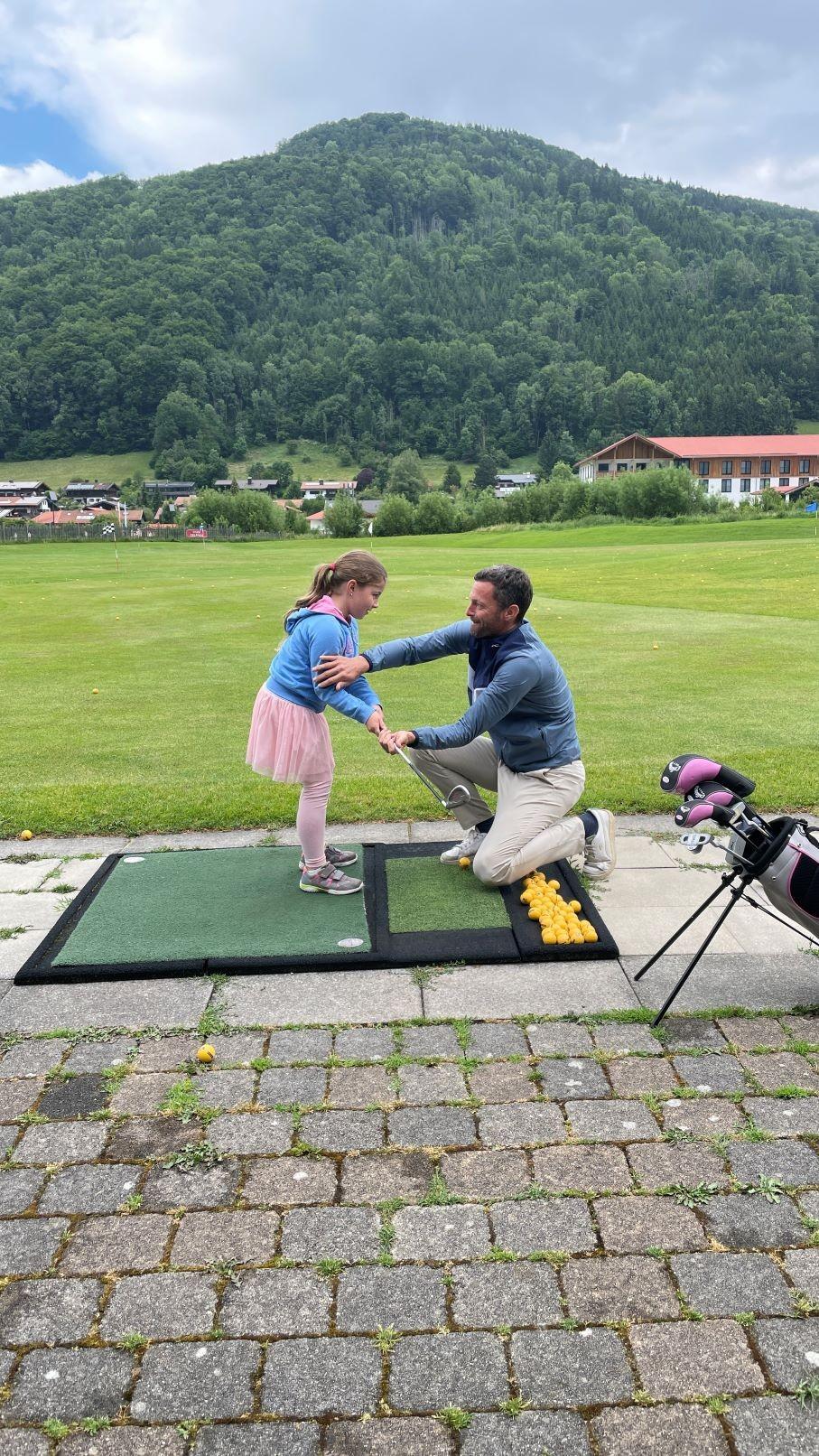 Golf-Profi Markus von Knoerzer zeigt einem Mädchen, wie man den Golfschläger richtig hält