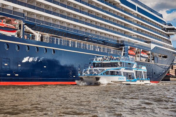 Fahrgastschiff fährt am Kreuzfahrtschiff vorbei