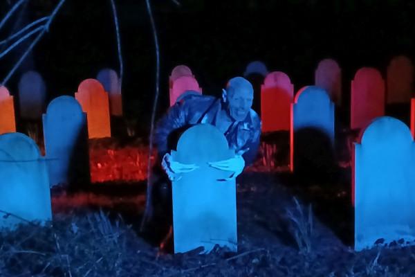 Vampir steigt Zähne fletschend aus der Gruft