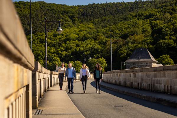 Besucher laufen über die Edertalsperre