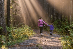 Eine Frau geht mit ihrem Kind im Wald spazieren