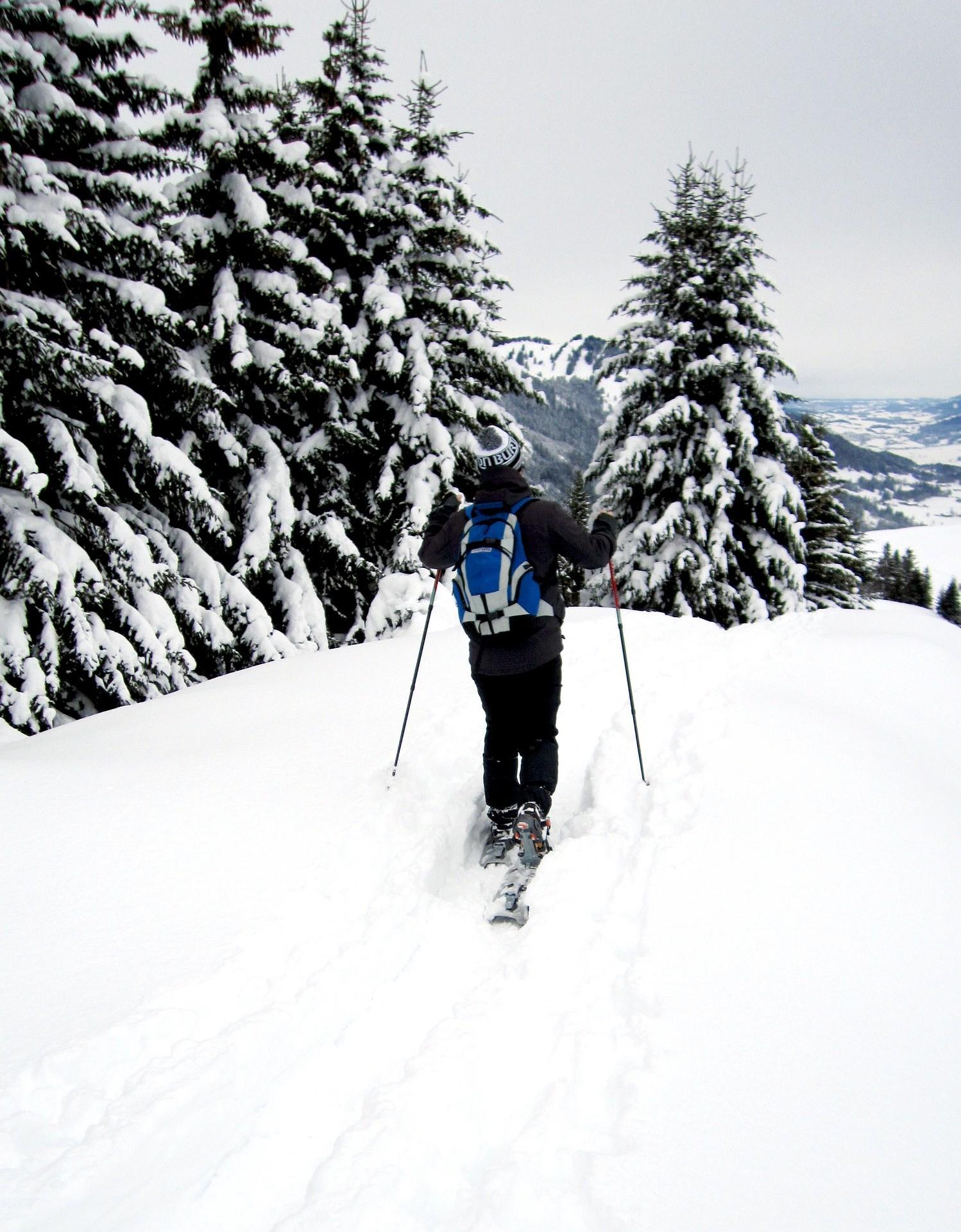 Eine Person geht bei einer Schneeschuh-Tour im hohen Schnee