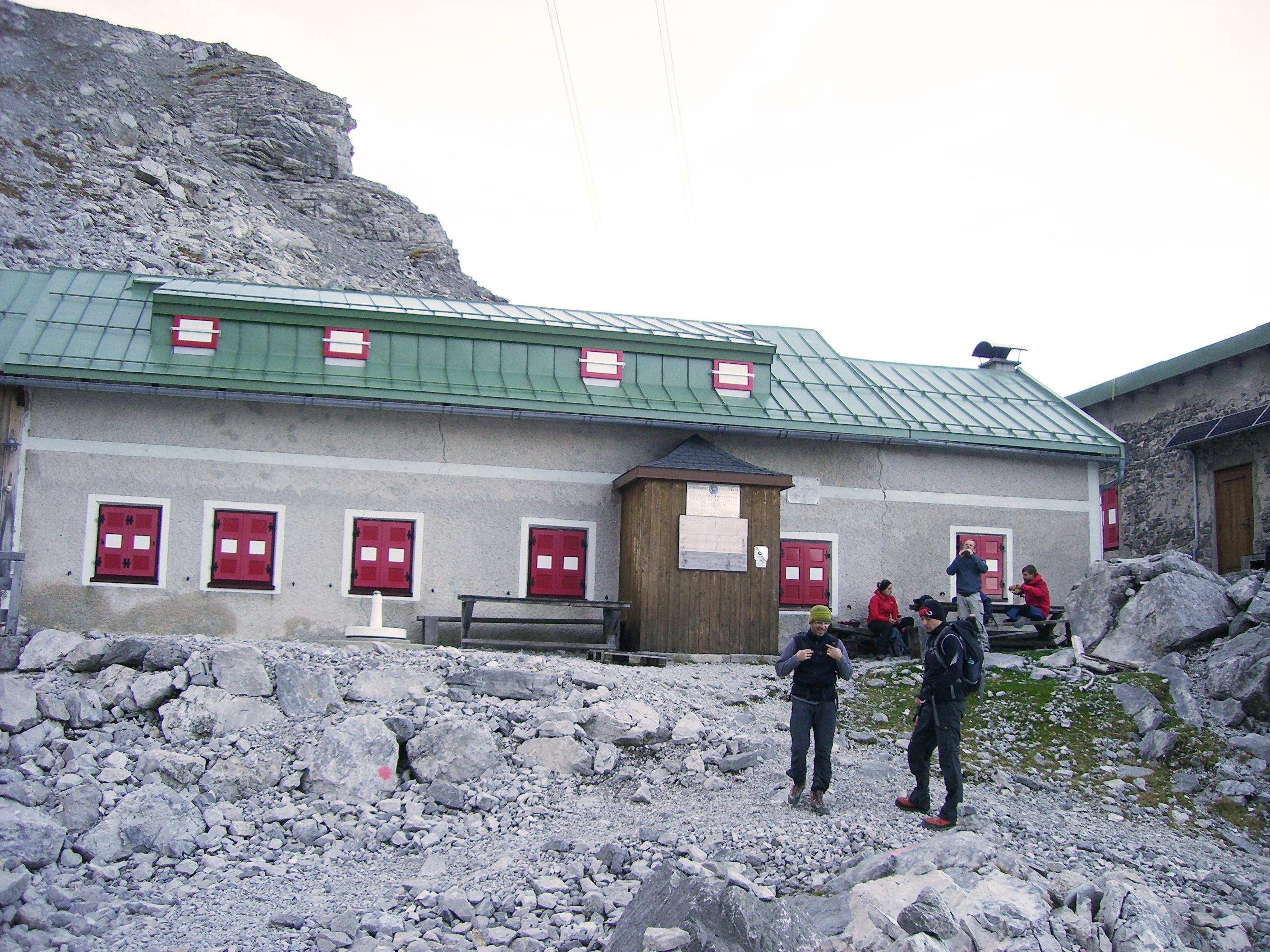 Menschen vor einer Hütte in den Alpen bei einer geführten Klettersteig-Tour