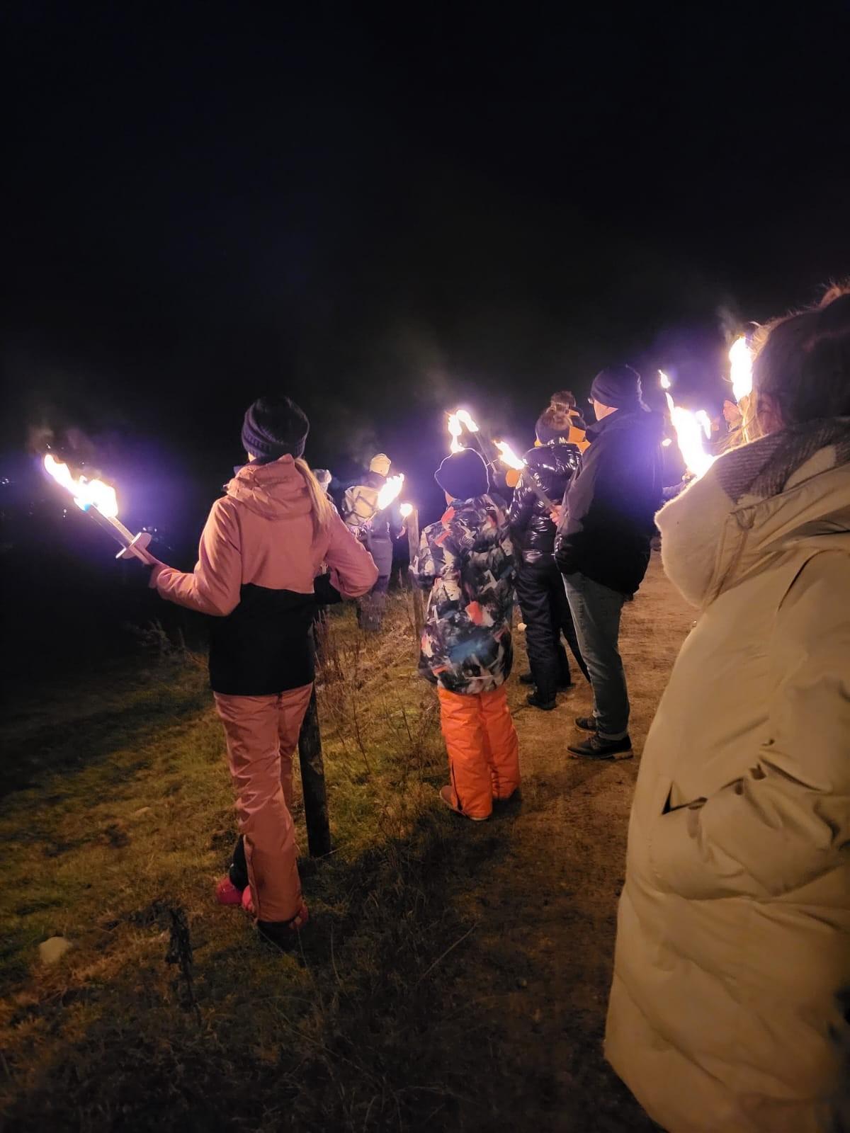 Eine Gruppe mit Fackeln bei einer Fackelwanderung in Reit im Winkl