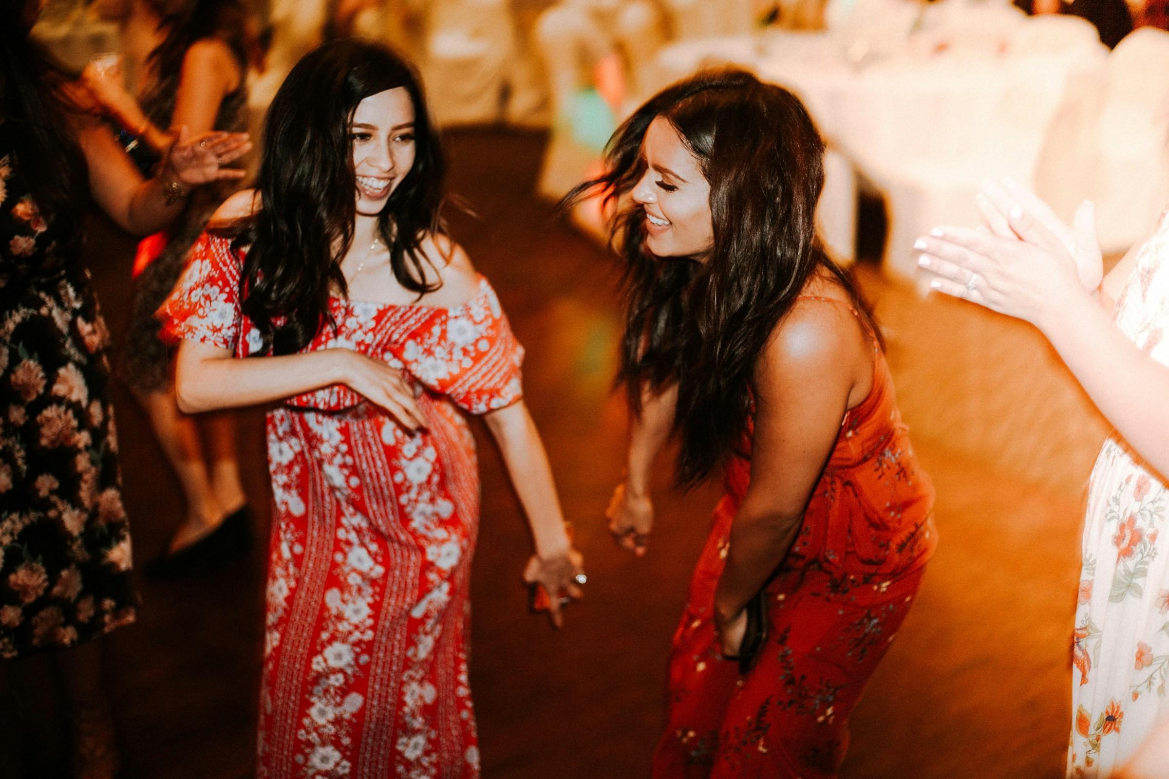 Zwei Frauen in roten Kleidern tanzen Salsa Cubana