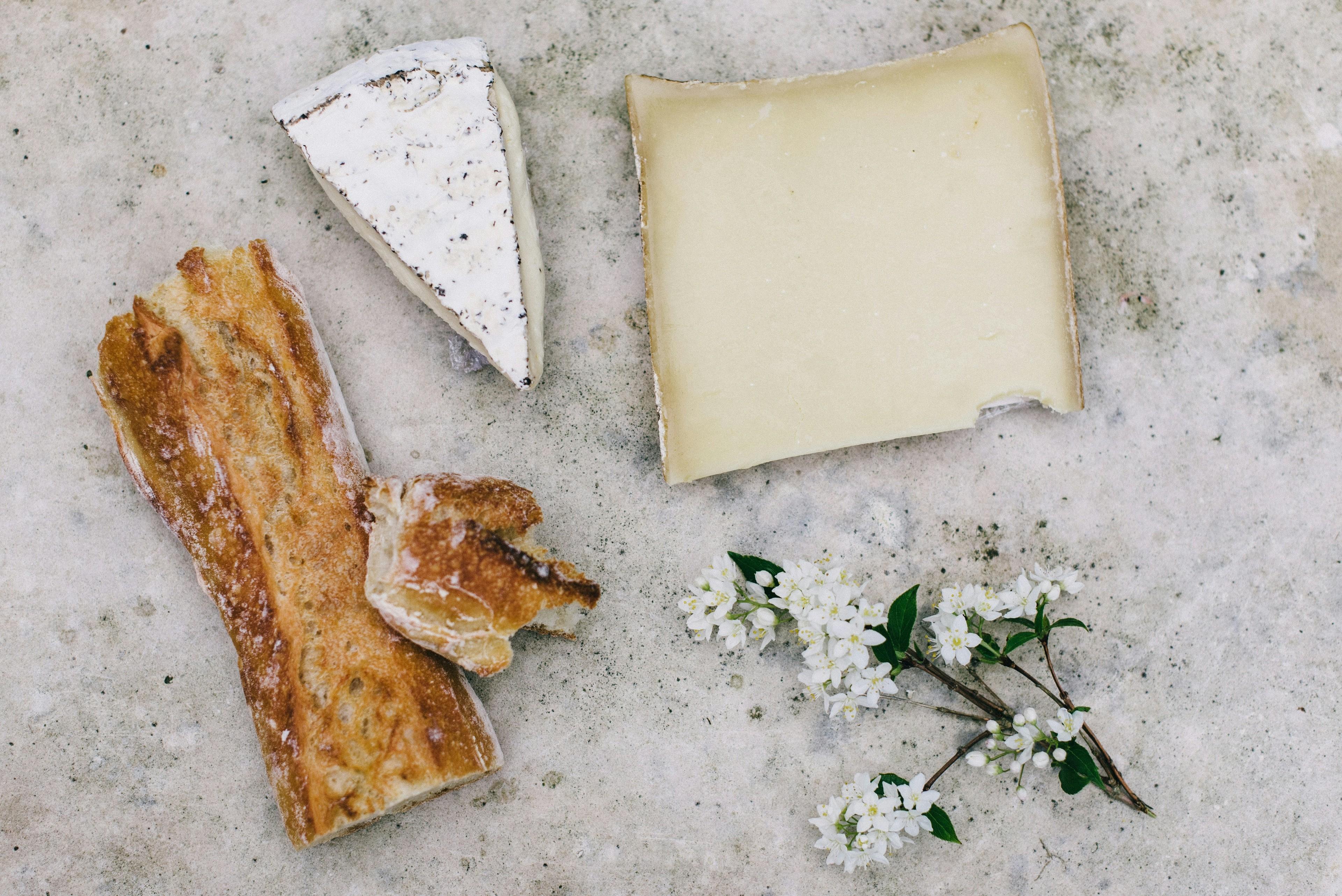 Eine Käse-Auswahl mit Brot und Blumen auf einem Tisch