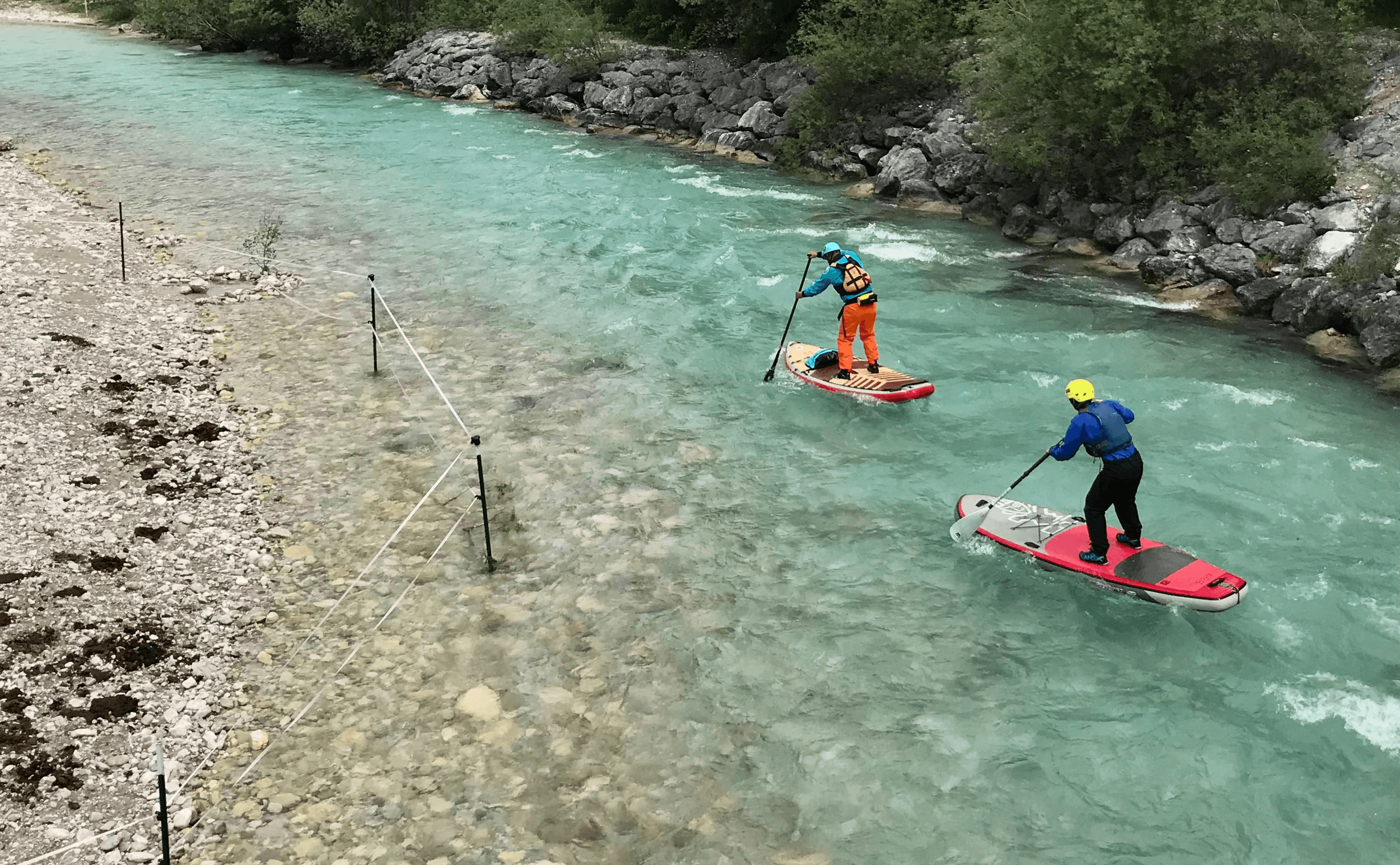 Zwei Personen stehen auf SUP-Boards und befahren die Loisach