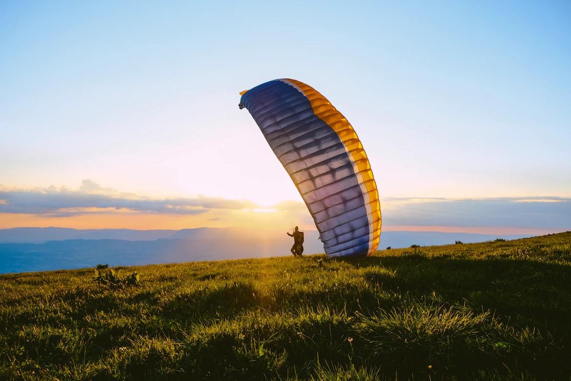 Eine Person mit Gleitschirm, der sich im Wind bauscht