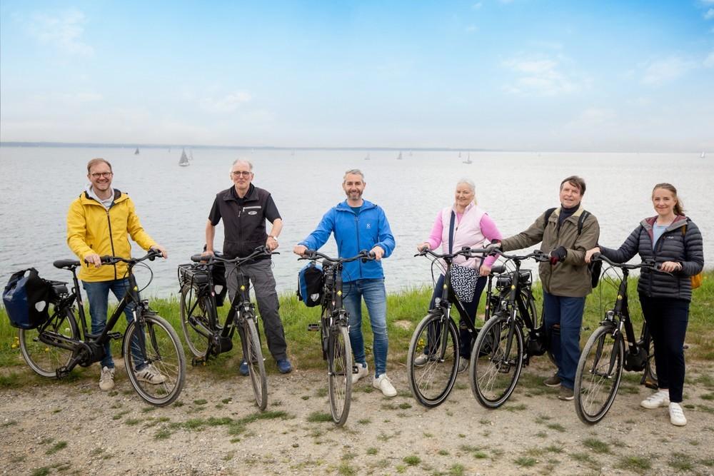 Eine Gruppe steht mit Fahrrädern an der Ostsee