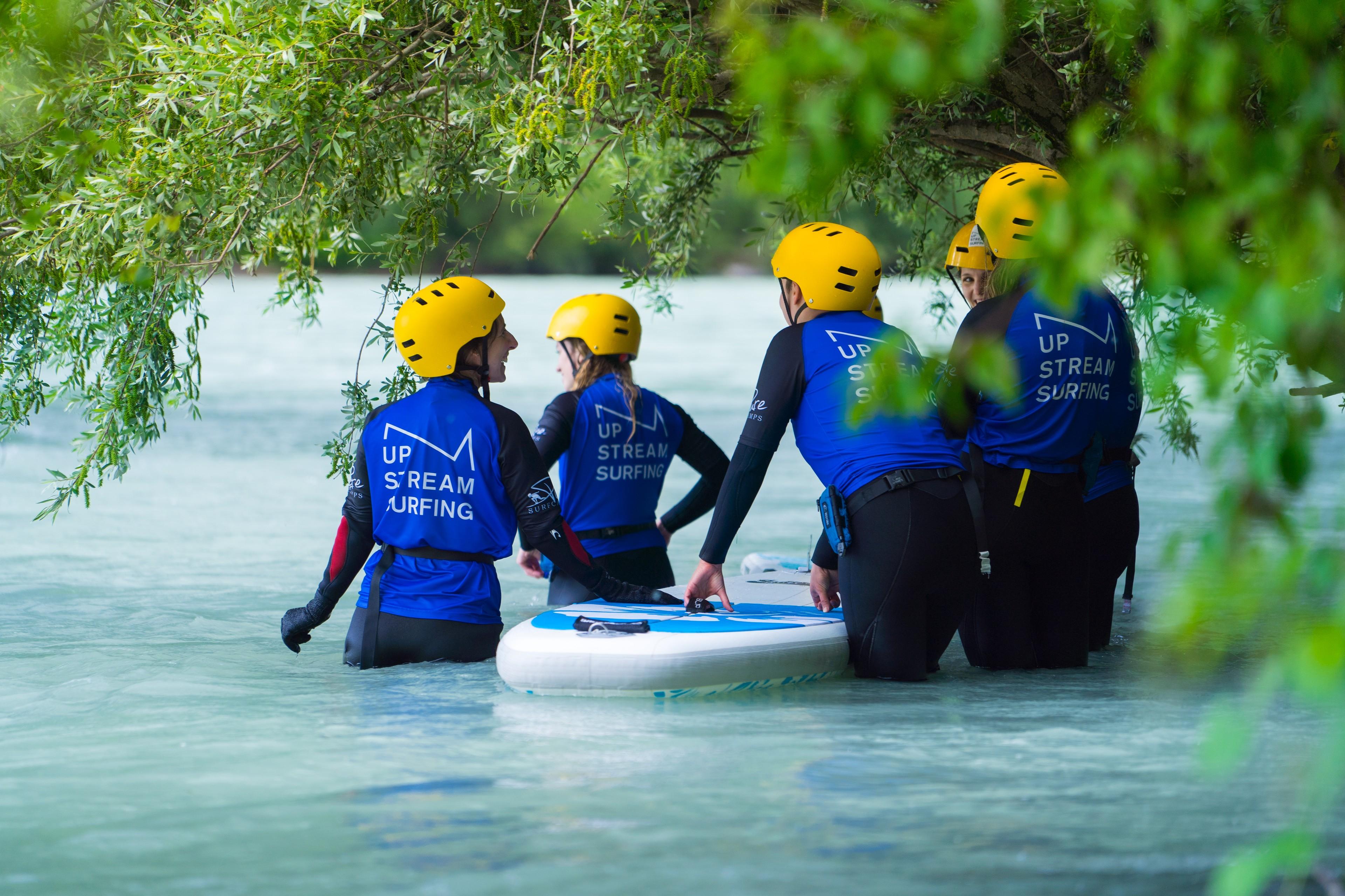 Eine Gruppe erhält eine Einweisung ins Fluss-Surfen auf dem Inn