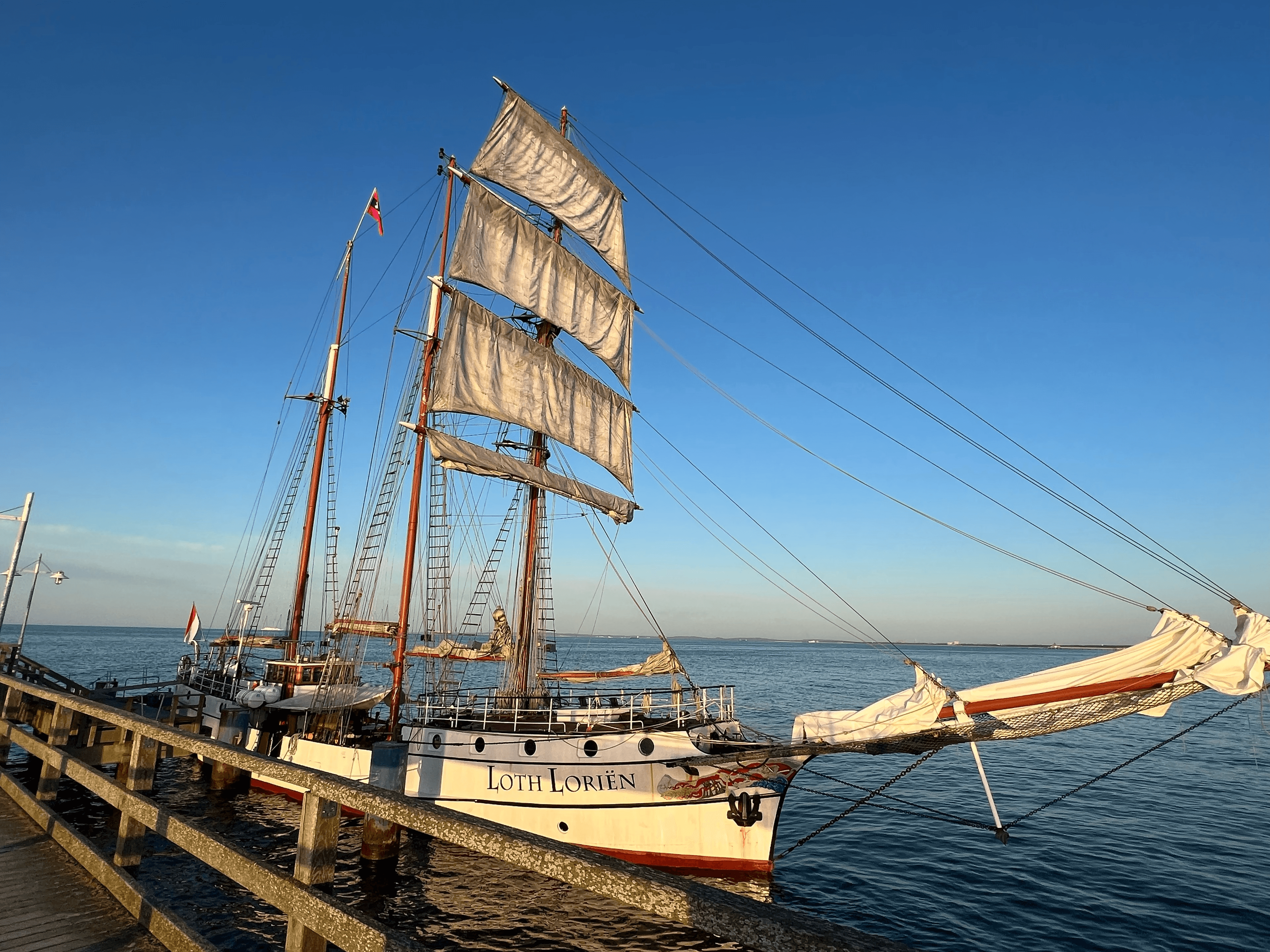 Das Traditionssegelschiff Loth Lorien liegt mit gerafften Segeln an der Seebrücke Grömitz