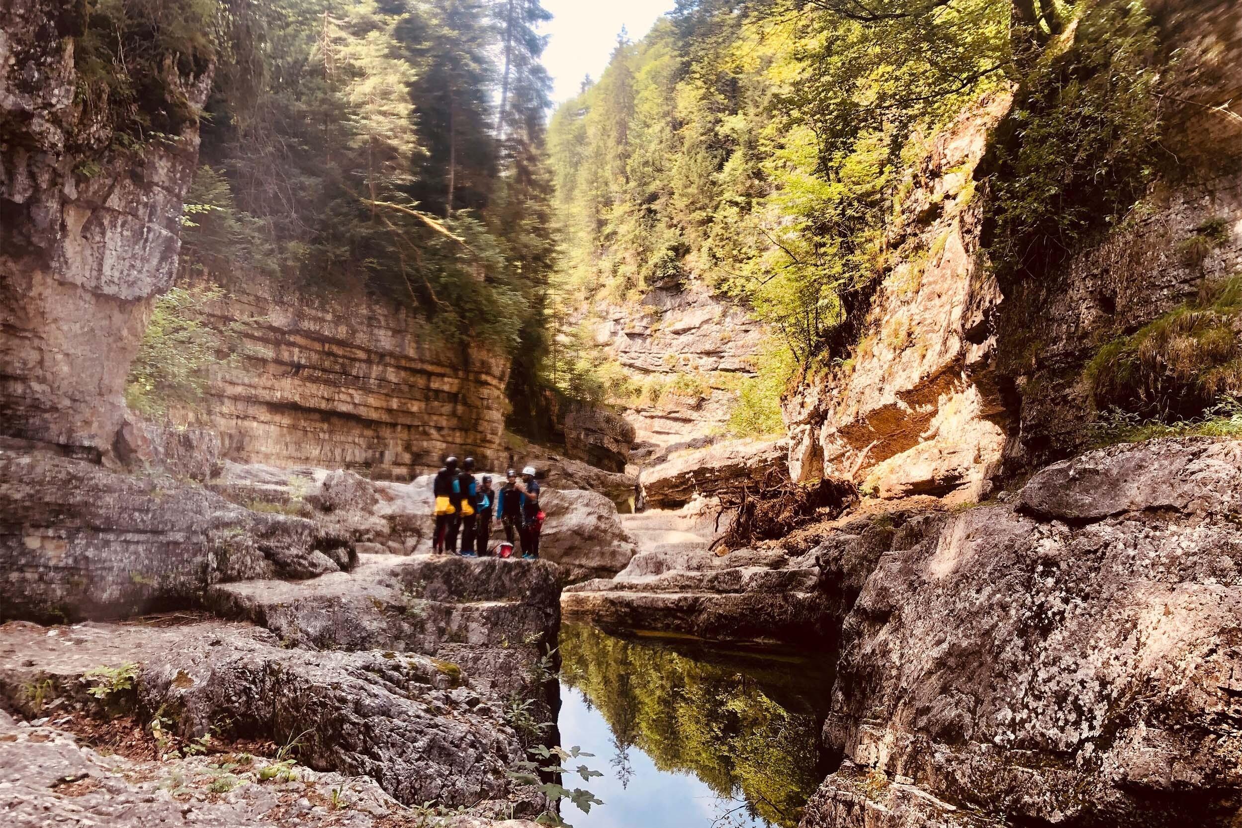 Eine Gruppe steht beim Canyoning in einer Schlucht in den Bergen