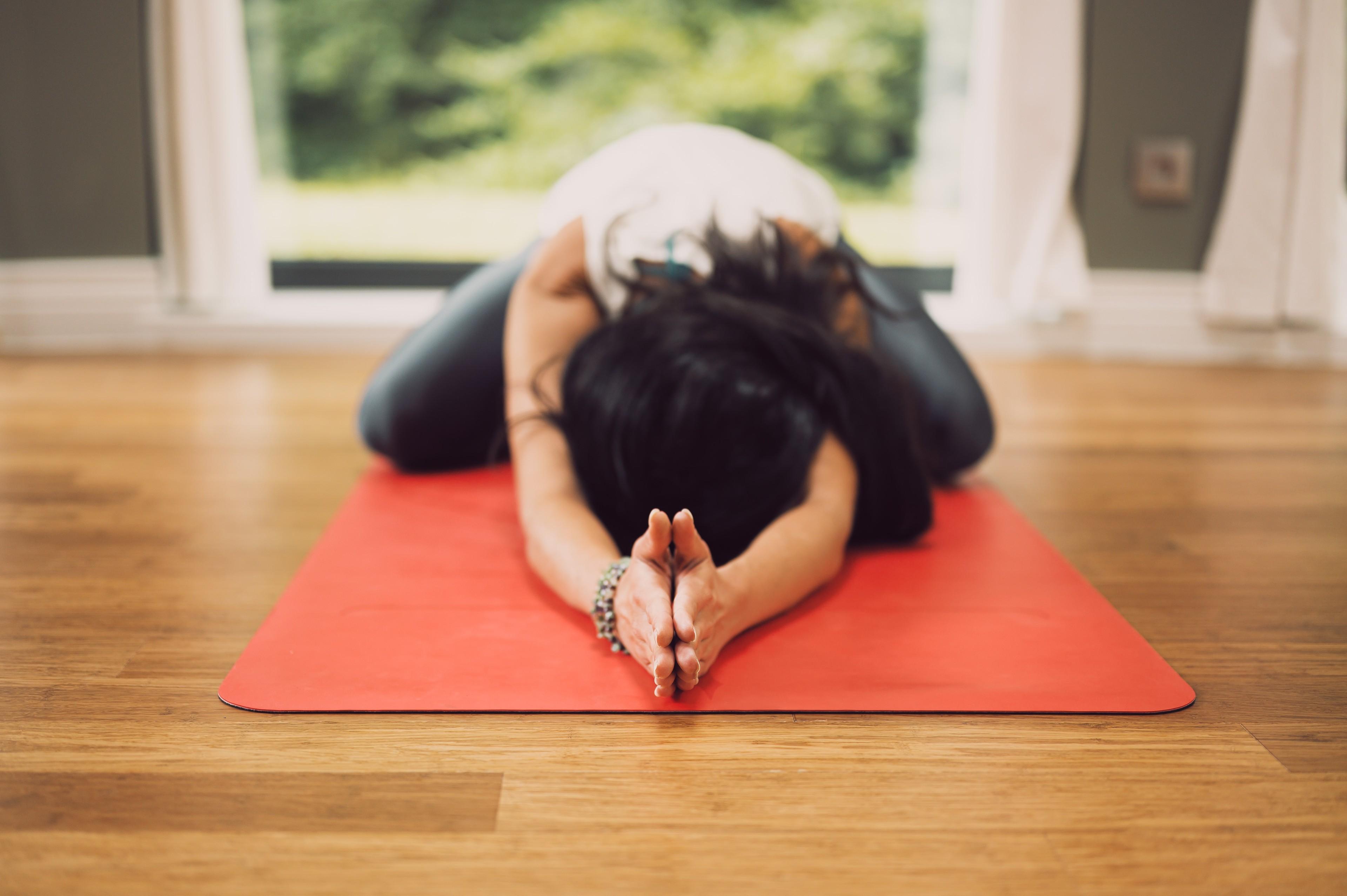 Eine Frau in Yoga-Pose auf einer Yoga-Matte