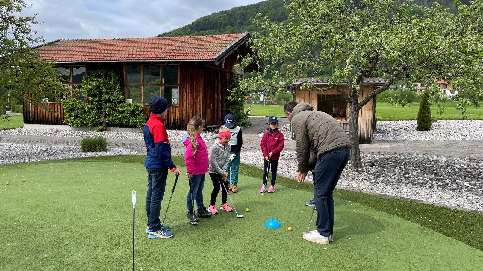 Kinder üben Putten auf dem Putting-Green