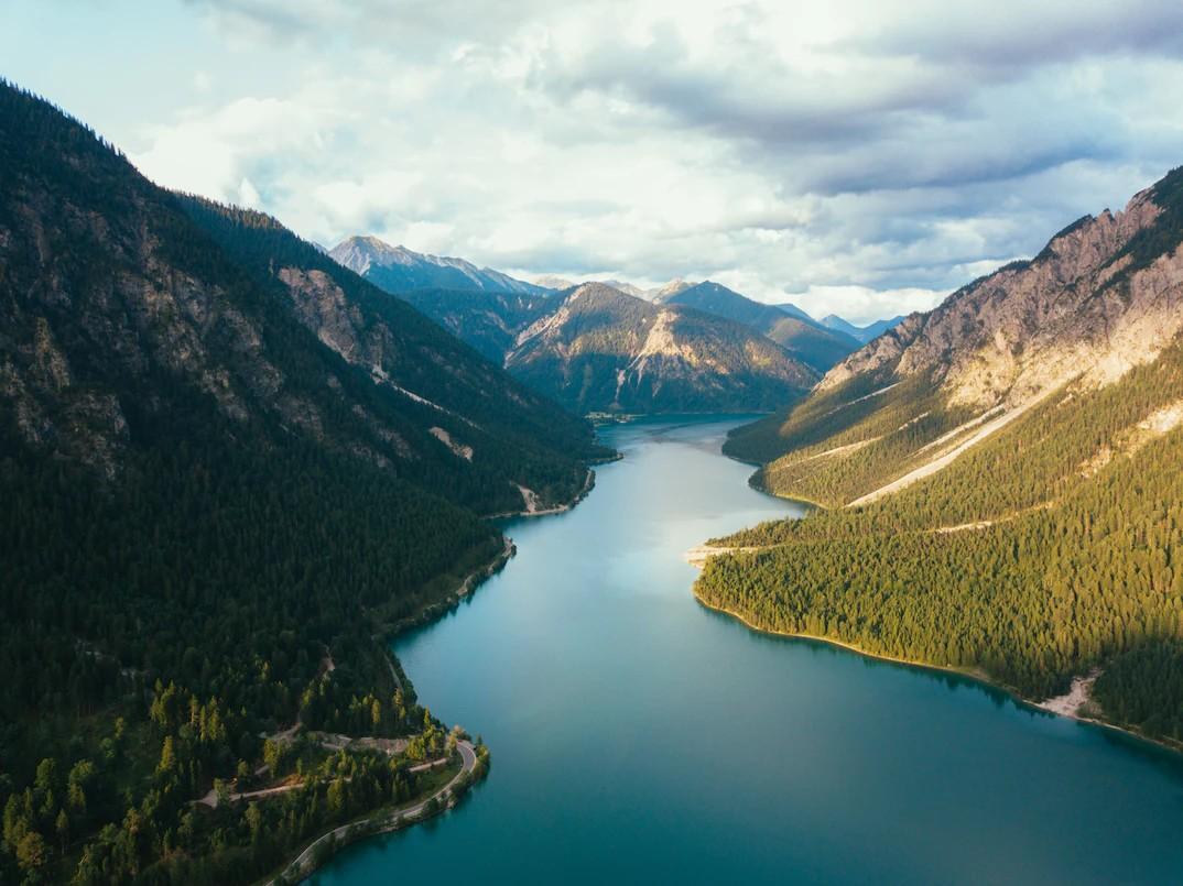 Der Plansee mit bewaldeten Berghängen und Gipfeln im Hintergrund