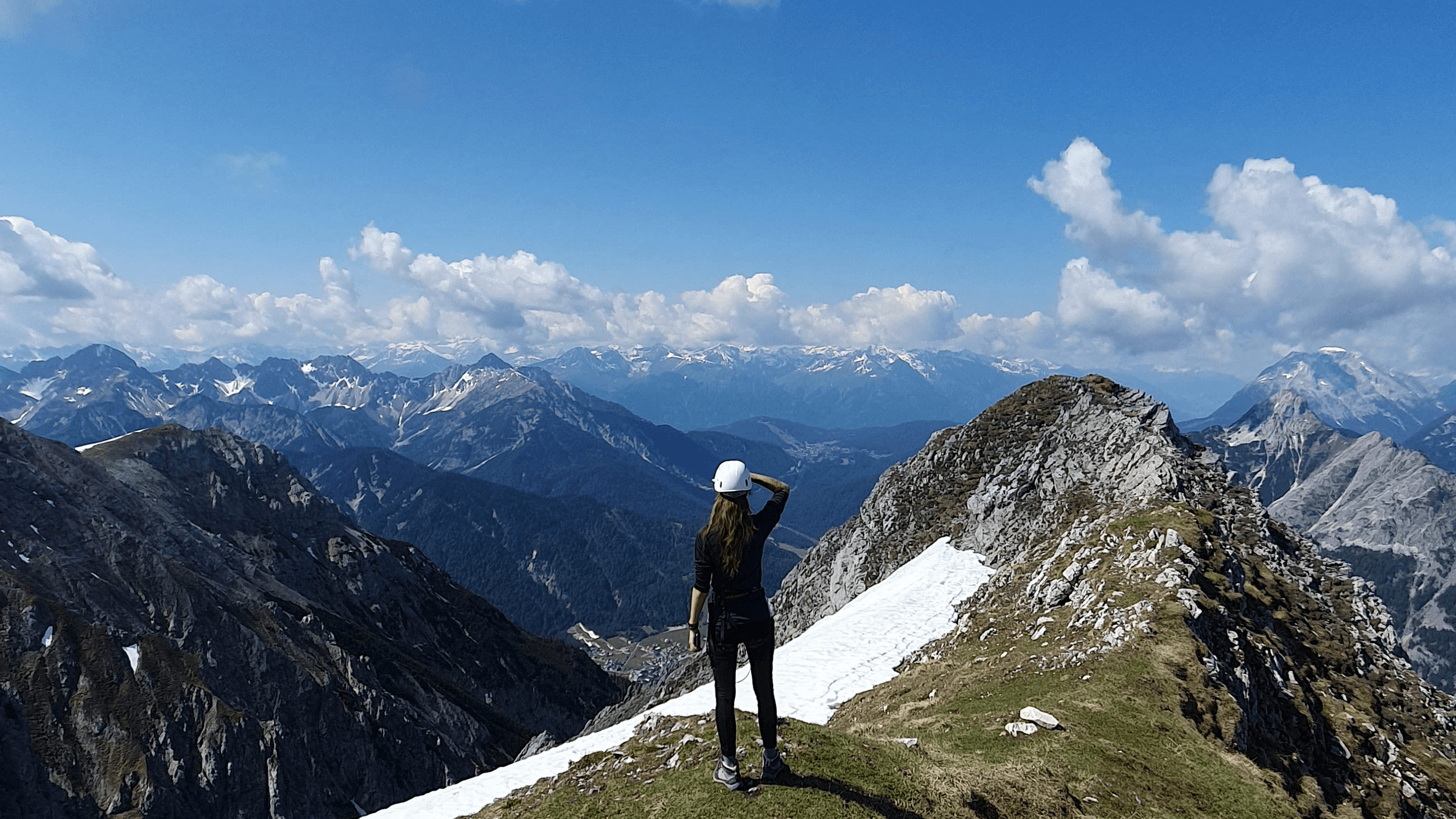 Eine Person blickt vom Klettersteig Mittenwald aufs umliegende Bergpanorama