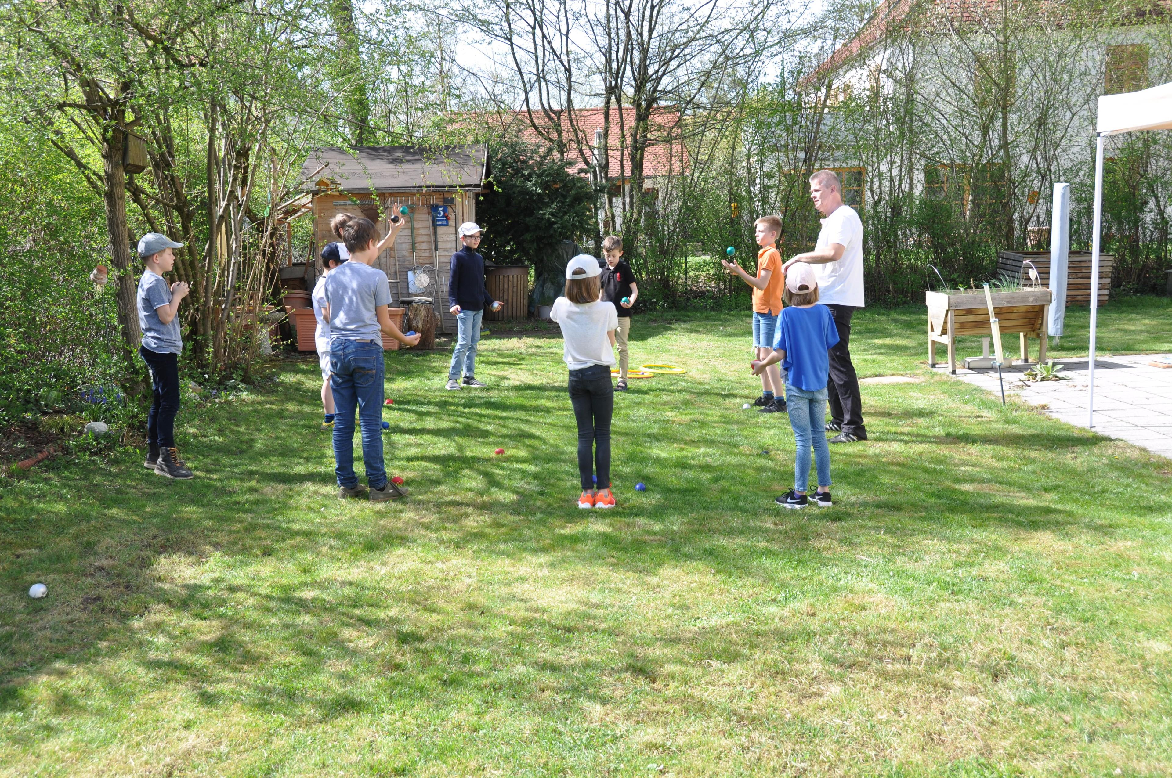 Kinder werfen bei einem Jonglier-Workshop in München Bälle in die Höhe