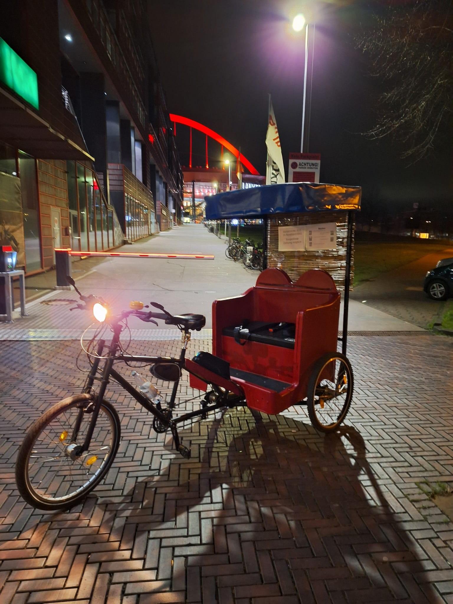 Eine Rikscha im nächtlichen Köln