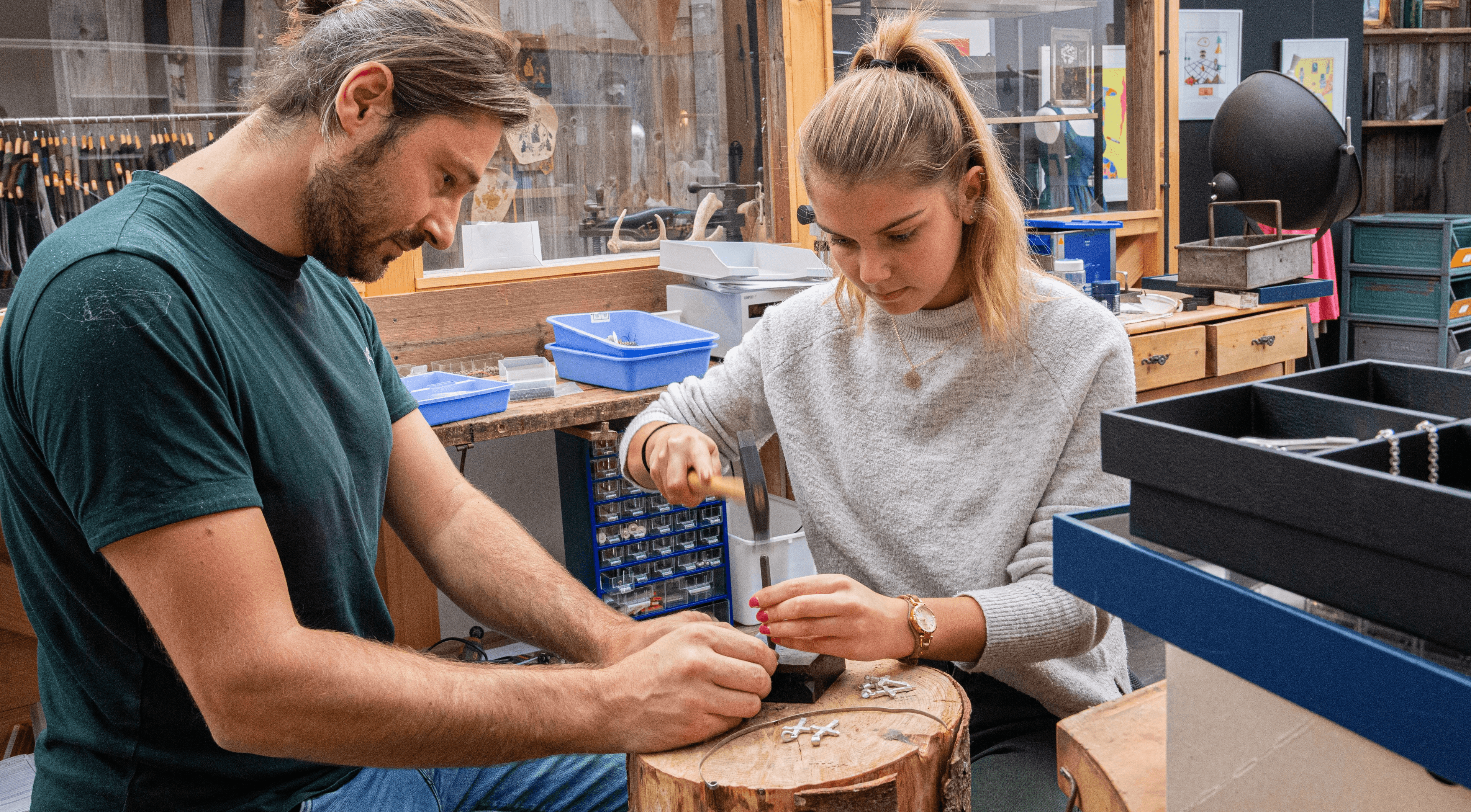 Teilnehmende stellen bei einem Schmuck-Workshop einen Gipfelkreuz-Anhänger her