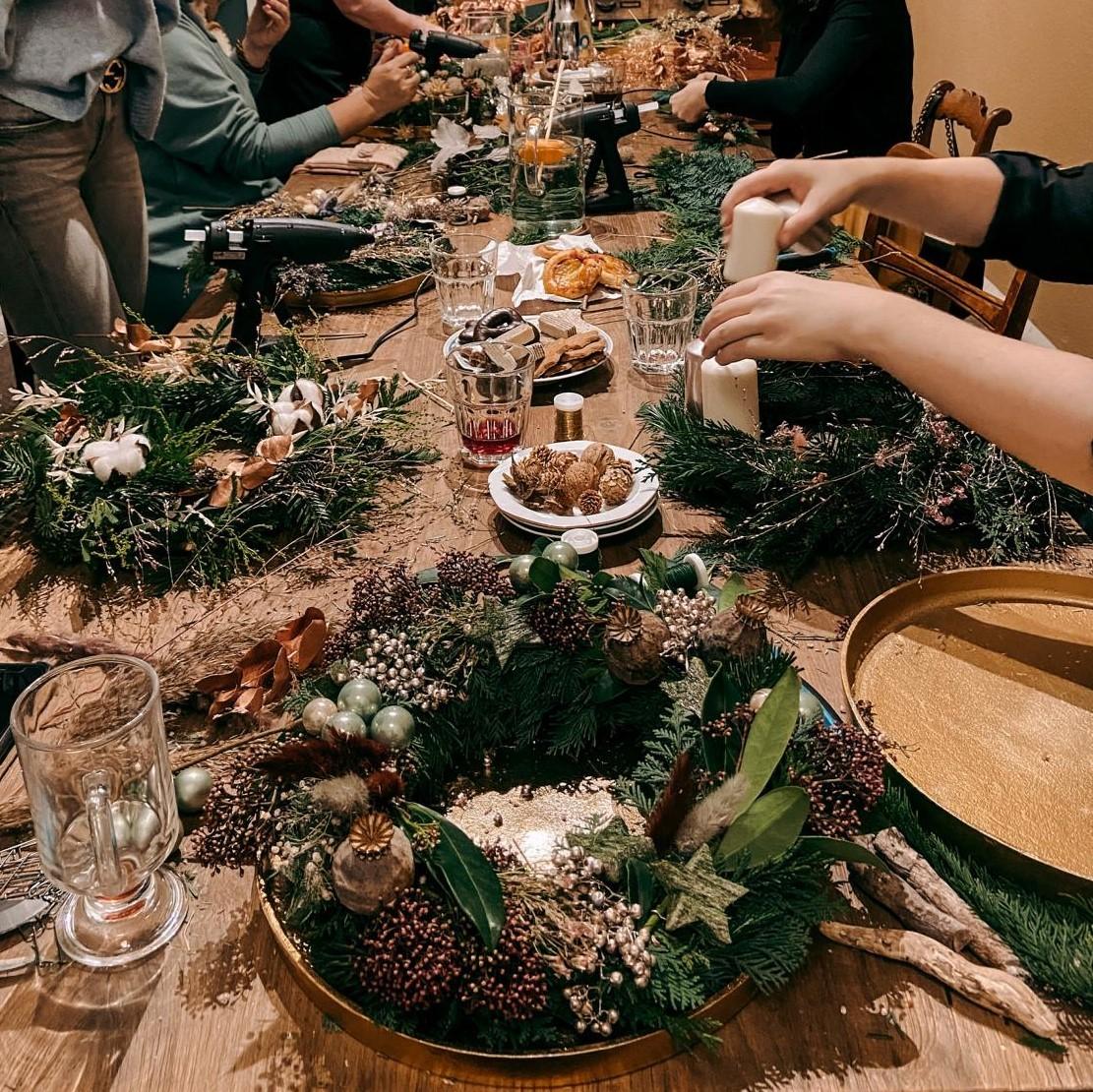 Adventskränze und Bastelmaterialien auf einem Tisch