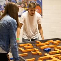 Eine Gruppe spielt Adventure Minigolf an einer Tischkicker-Bahn in Berlin