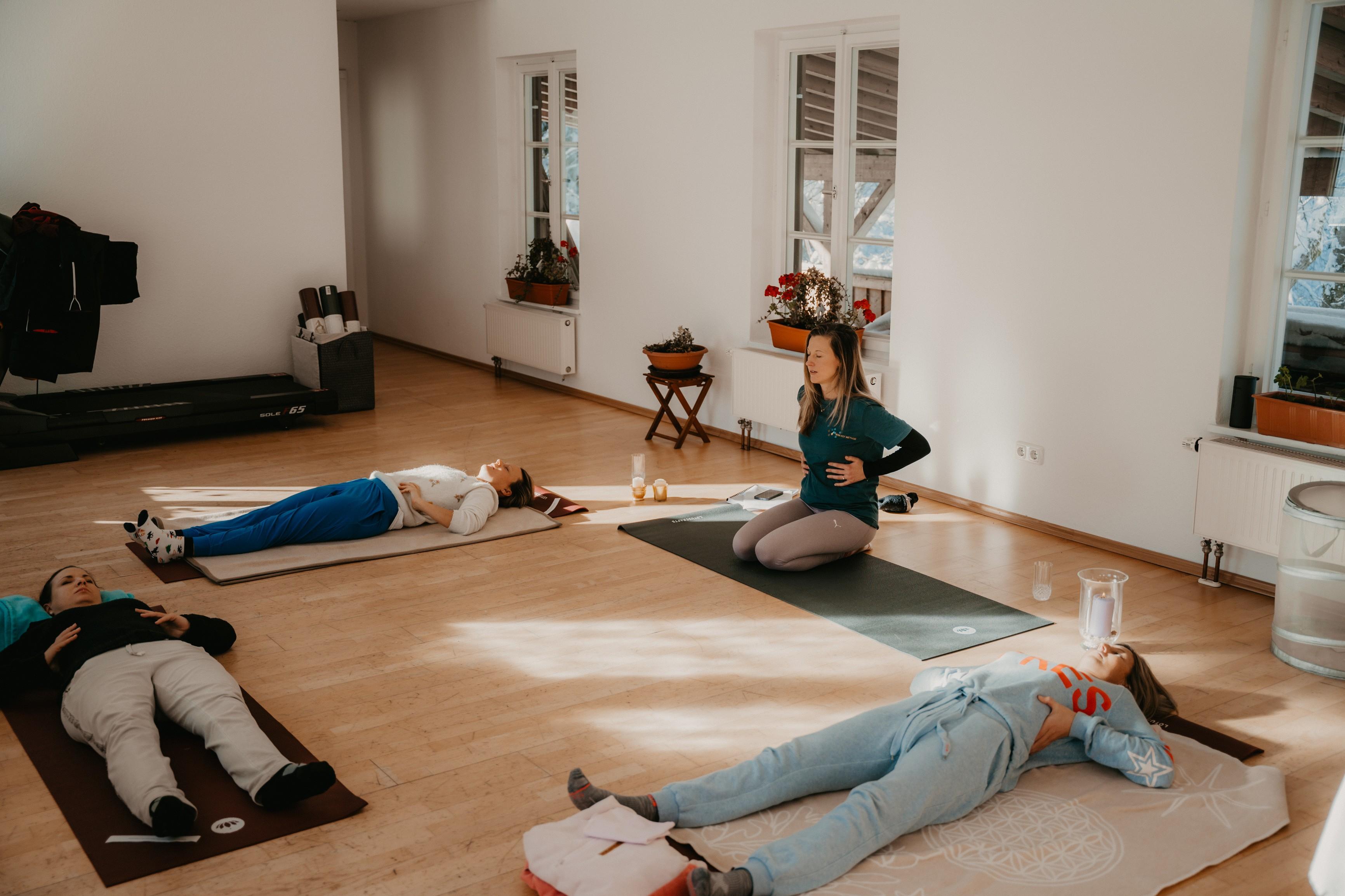 Vier Frauen machen Atemübungen auf Yogamatten beim Eisbaden-Workshop