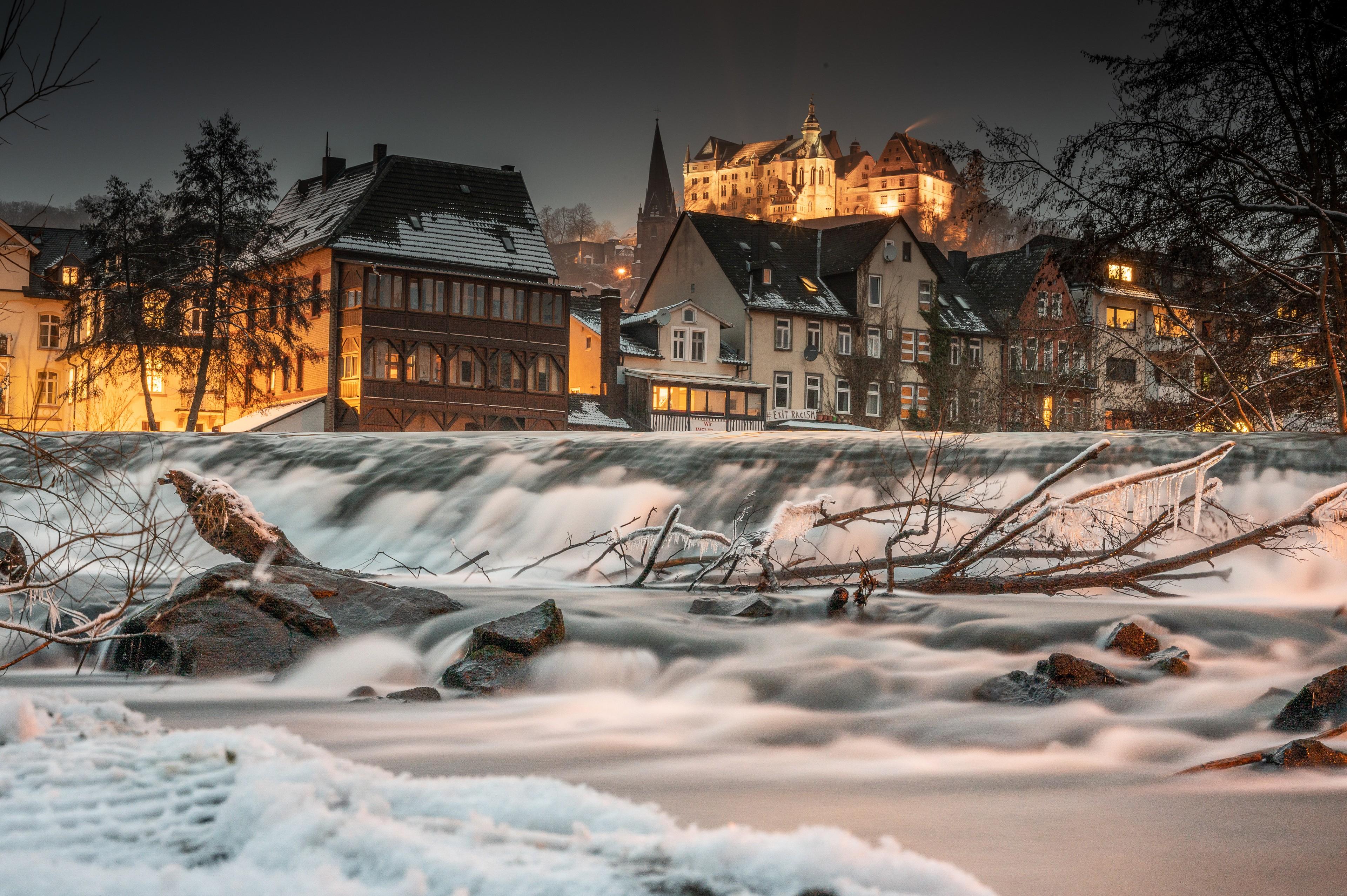 Marburg im Winter bei Nacht, die Lahn im Vordergrund