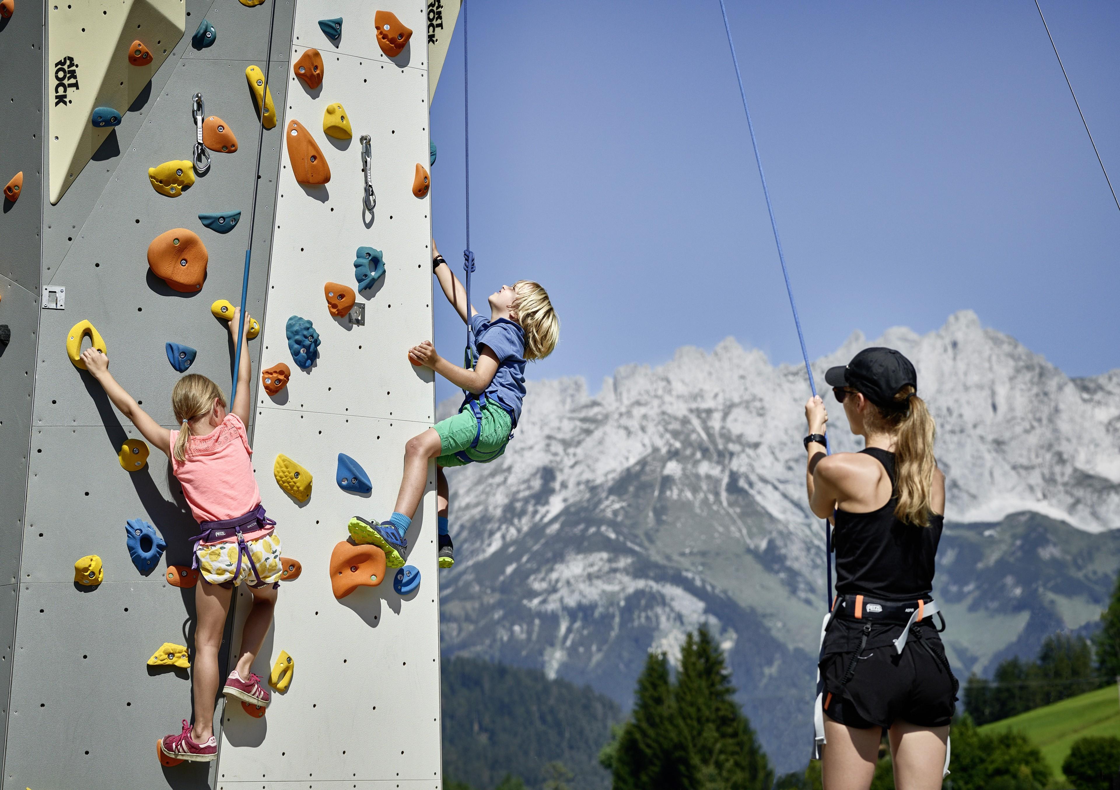 Kinder klettern an einer Kletterwand bei Kitzbühel
