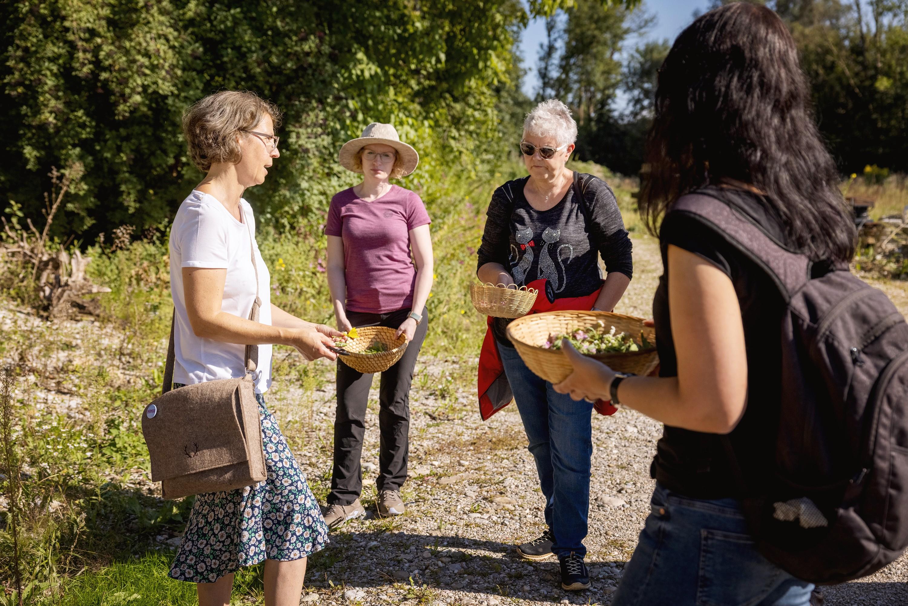 Teilnehmende einer Kräuterwanderung im Chiemgau mit gesammelten Kräutern