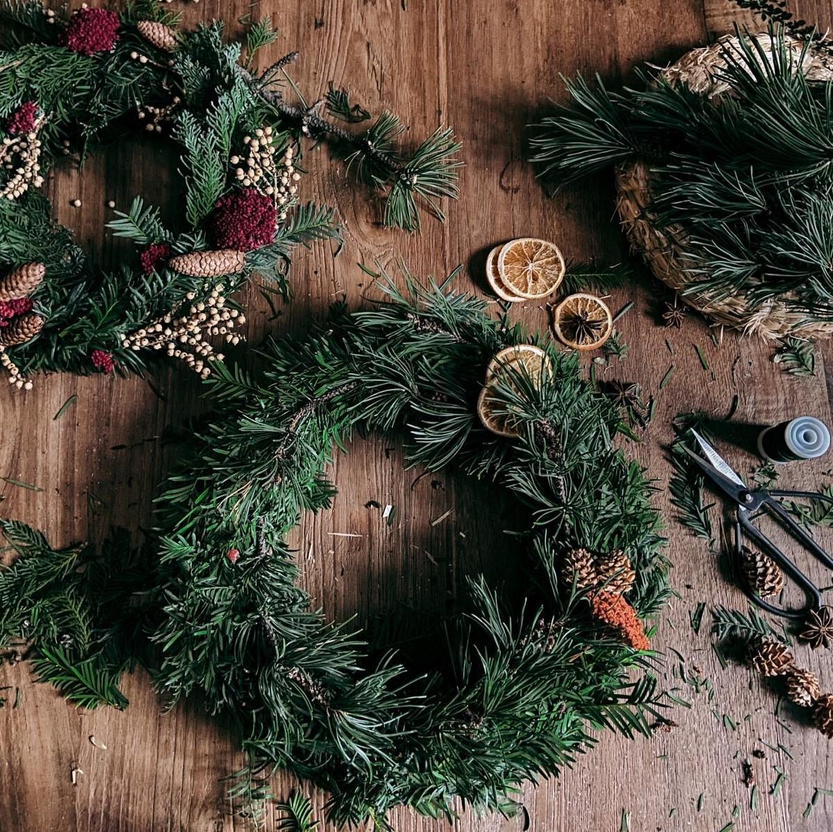 Ein Adventskranz-Rohling mit Materialien und Werkzeug auf einem Tisch