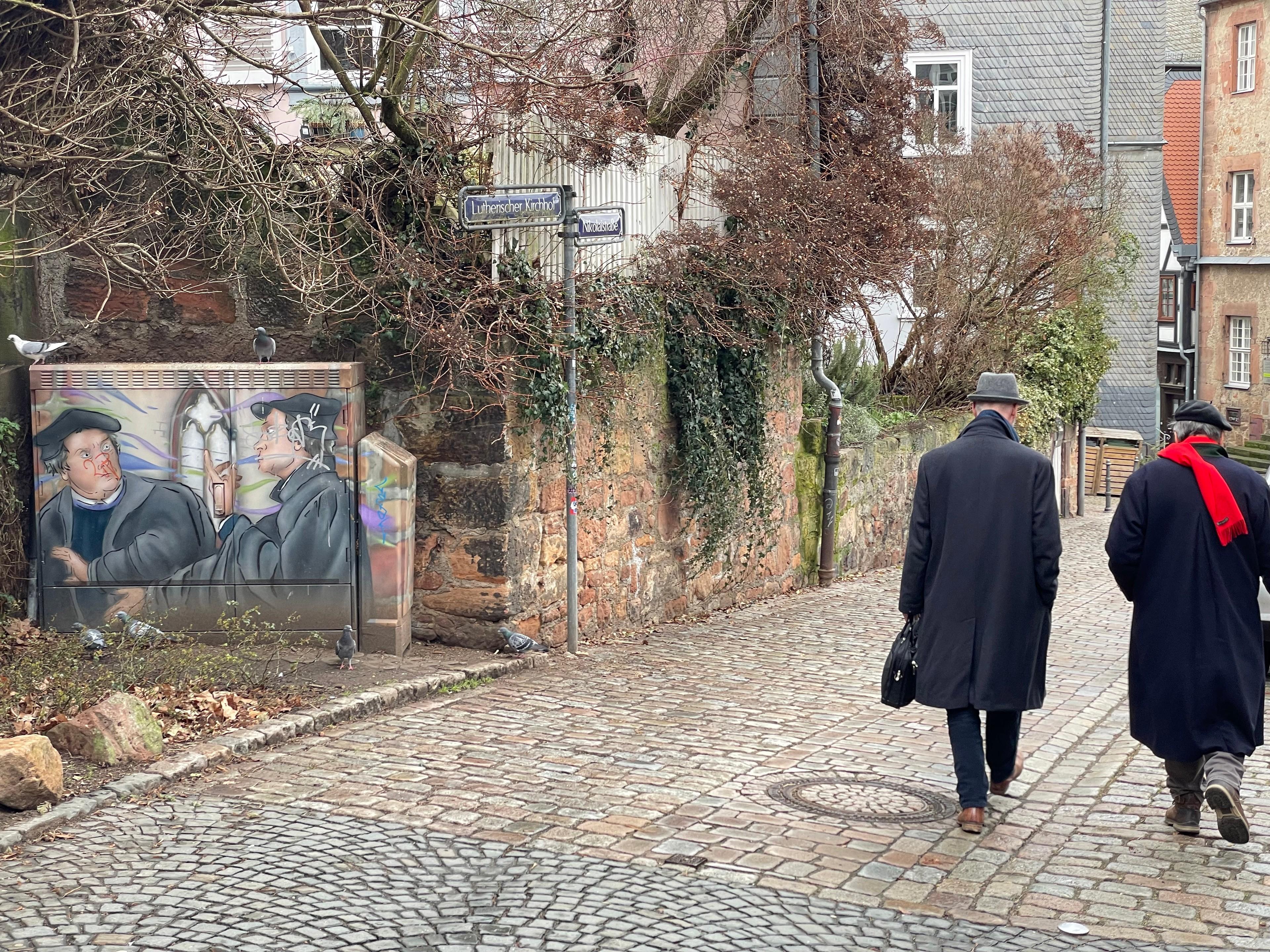Ein Wandgemälde und Menschen in der Marburger Altstadt