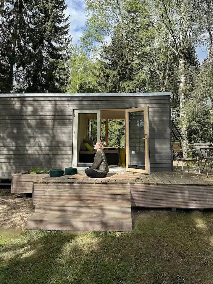 Außenansicht eines Tiny Houses in der Lüneburger Heide mit Bäumen ringsum