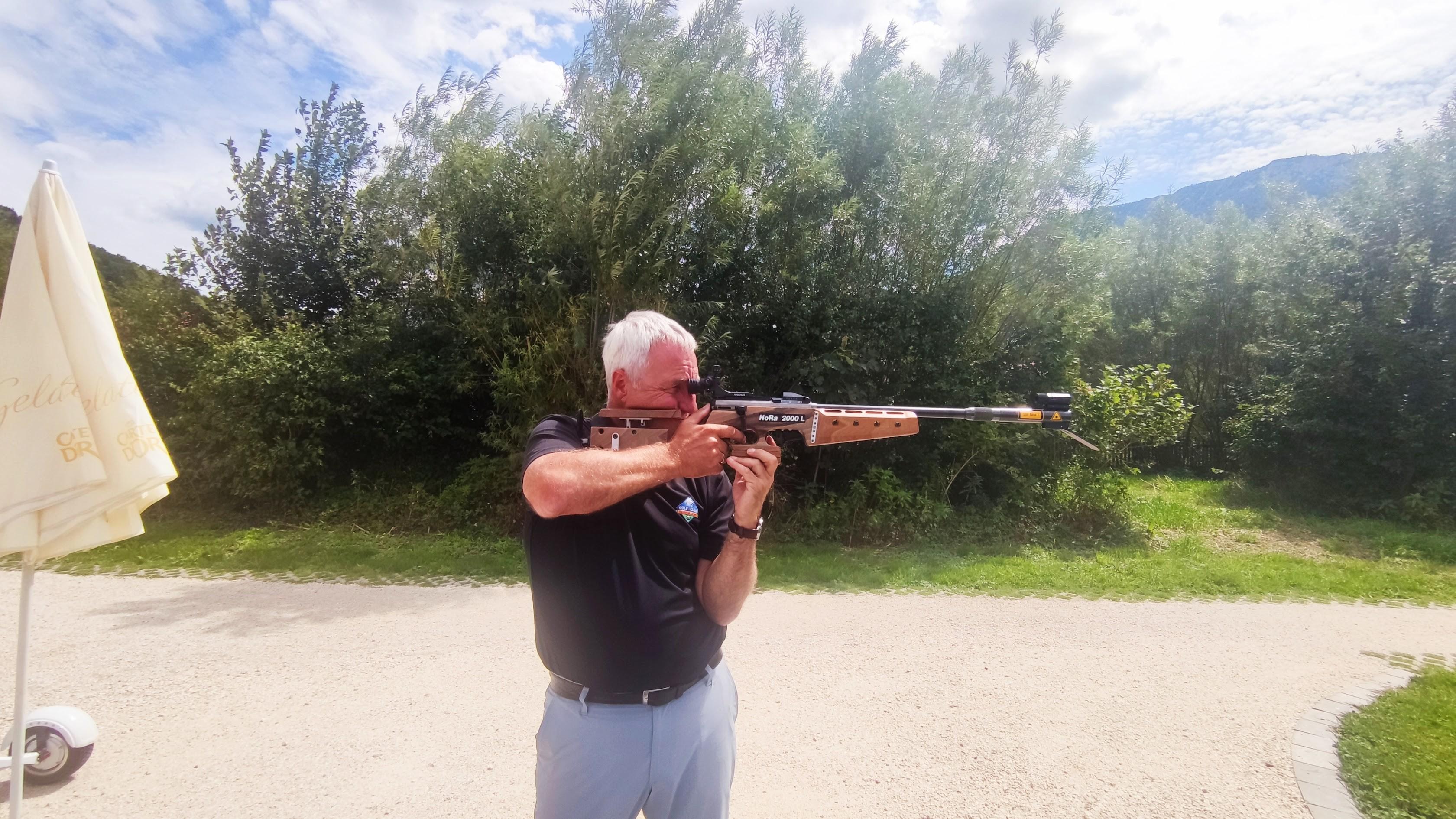 Ein Mann schießt mit einem umgerüsteten Biathlon-Gewehr auf einer Laser-Biathlon-Anlage