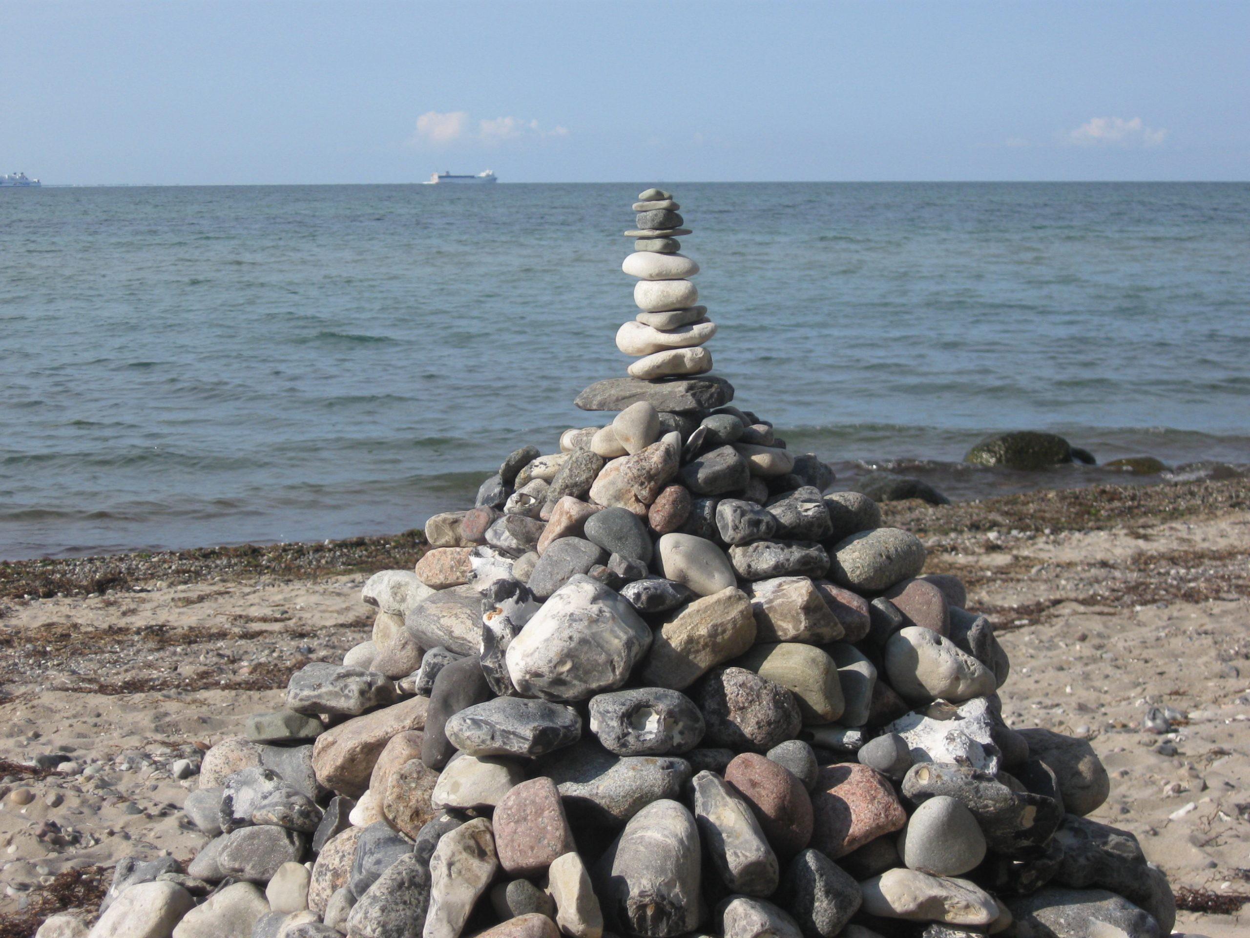 Steine sind an der Ostsee zu einer Pyramide getürmt